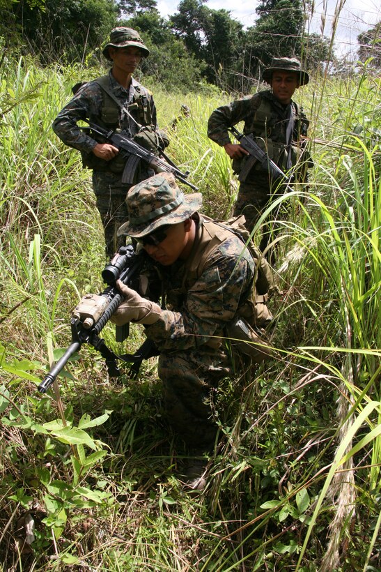 Guatemalan Army Special Forces soldiers or "Kaibiles" observe how a U.S. Marine positions himself to post security during a jungle patrol exercise at Poptun Training Camp in Poptun, Guatemala, Sept. 11.  Patrolling in jungle terrain was part of the subject-matter expert exchange between Kaibil soldiers and Marines of Special-Purpose Marine Air-Ground Task Force Continuing Promise 2010.
