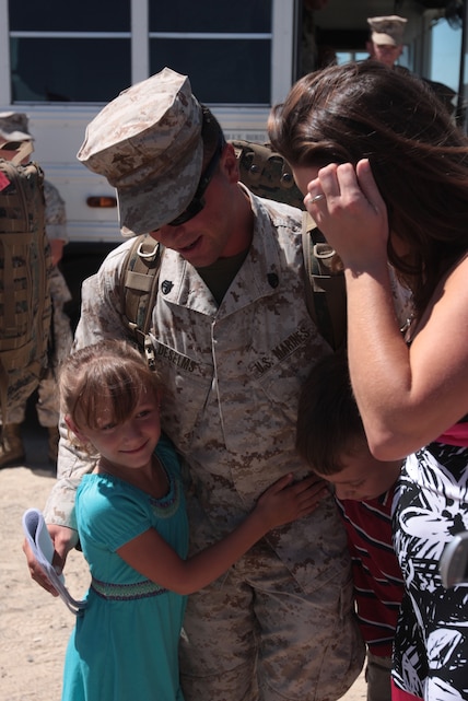 Staff Sgt. James Deselms, the nuclear biological chemical staff noncommissioned officer in charge of 7th Marine Regiment Advanced Party, holds his son and daughter after being deployed to Afghanistan for a year at the homecoming party Saturday at Del Valle Field.