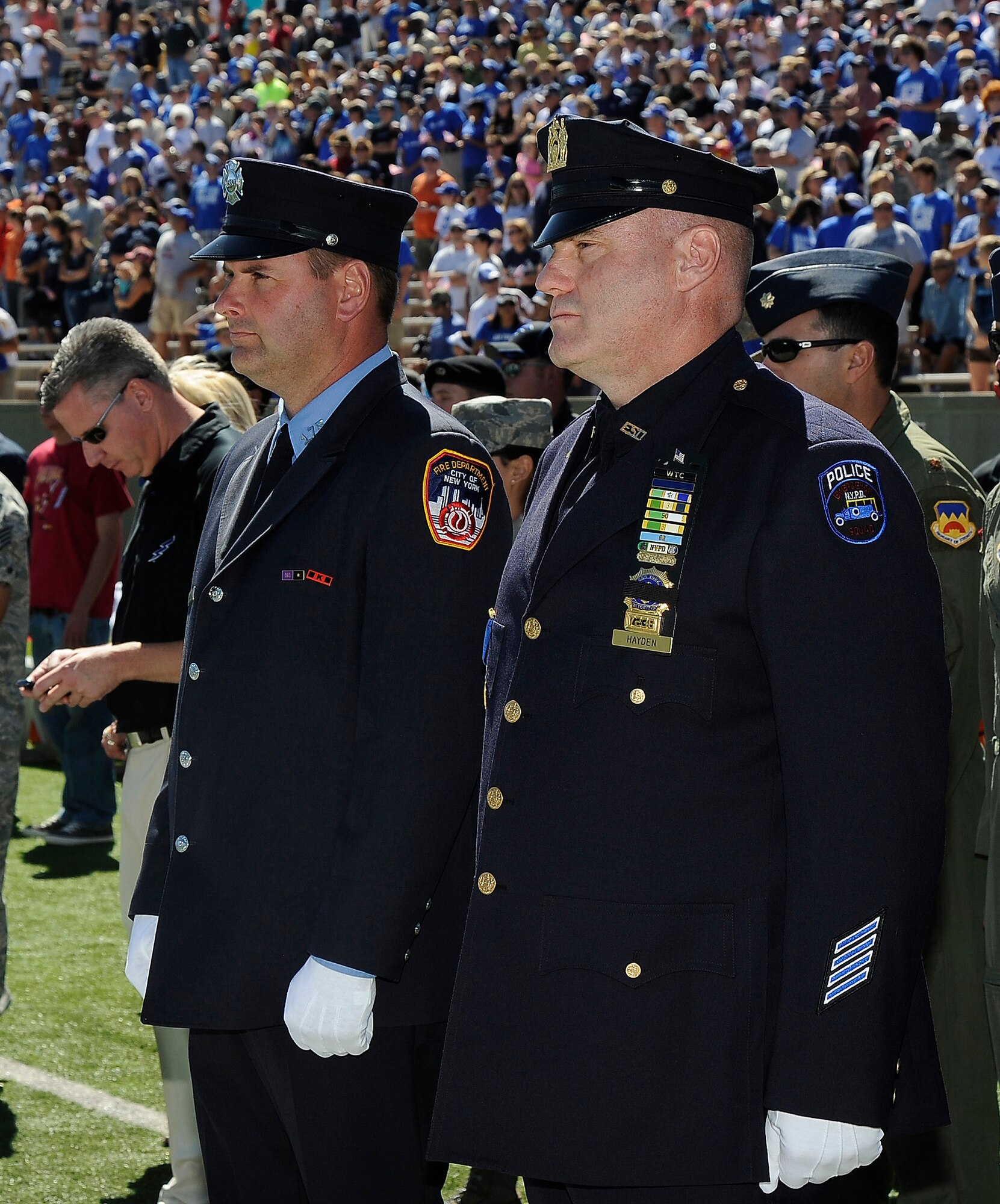 NYPD detective Steve Hayden, right, and FDNY firefighter Kenny Haskell were honorary game captains for the Air Force-BYU game at Falcon Stadium Sept. 11, 2010. A Wings of Blue jump with an American flag flown at the World Trade Center was canceled due to high winds. (U.S. Air Force photo/Rachel Boettcher)