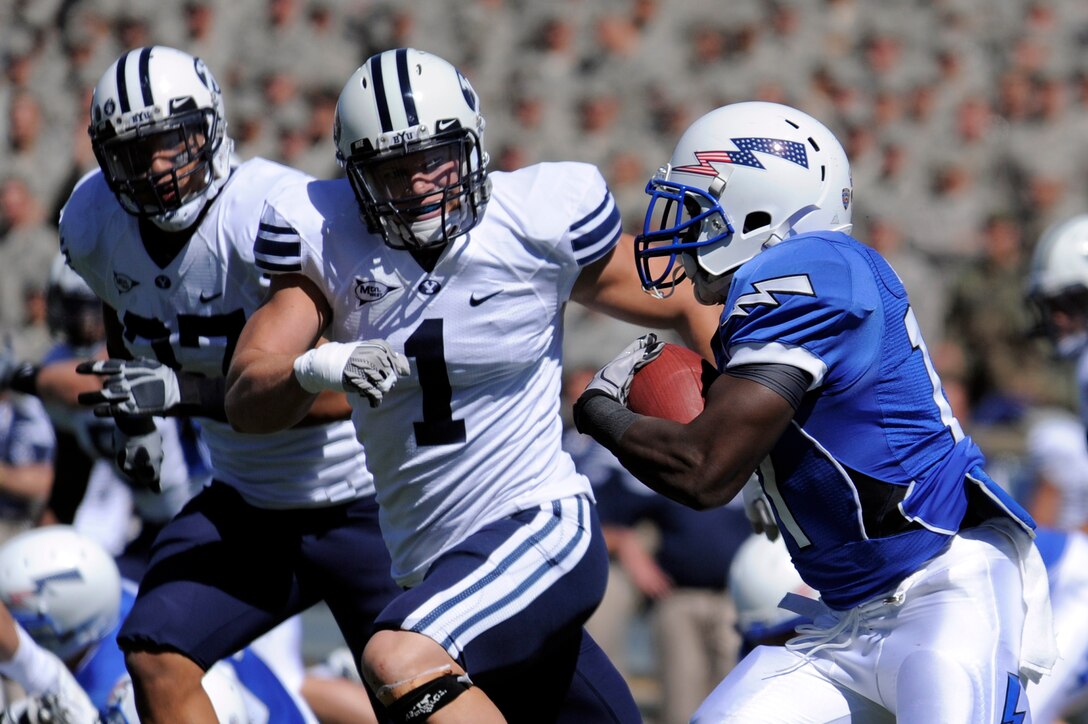 Falcons running back Asher Clark turns the corner upfield against Cougars defenders Vic So'oto (left) and Jordan Pendleton during the Air Force-BYU game at Falcon Stadium Sept. 11, 2010. Clark, a second-class cadet and native of Lawrenceville, Ga., had 121 yards on 18 carries in Air Force's 35-14 victory. (U.S. Air Force photo/Mike Kaplan)