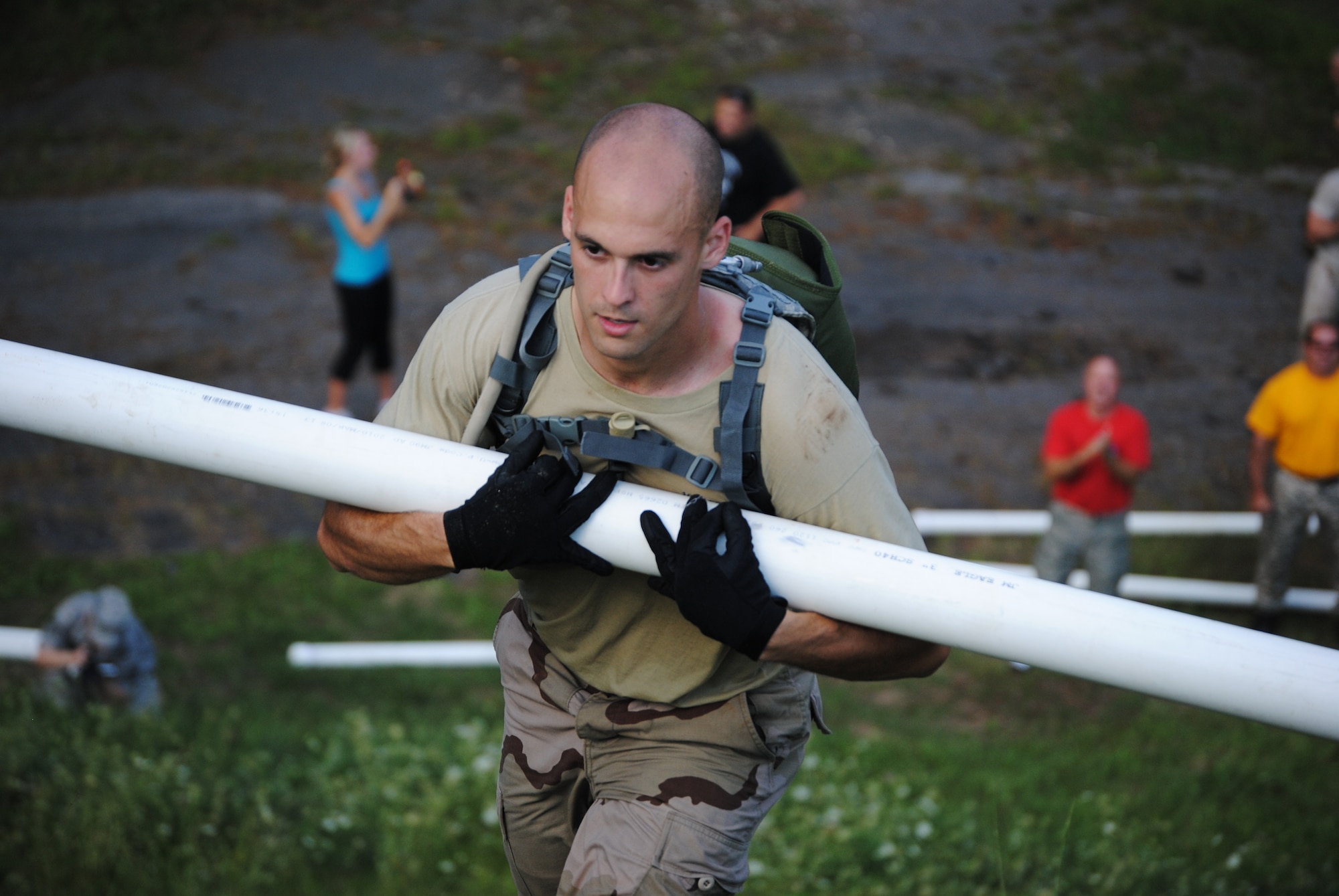 Staff Sgt. Dedrick Baublitz from the 103rd Security Forces Squadron cradles a water-filled PVC pipe up a hill as a member of the Connecticut Air National Guard Emergency Service Team during the Connecticut SWAT Challenge physical fitness test in West Hartford, Aug. 26, 2010. The Guard team took 20th place overall and 10th place in the physical fitness challenge. (Photo courtesy of Ms. Denise Davis)