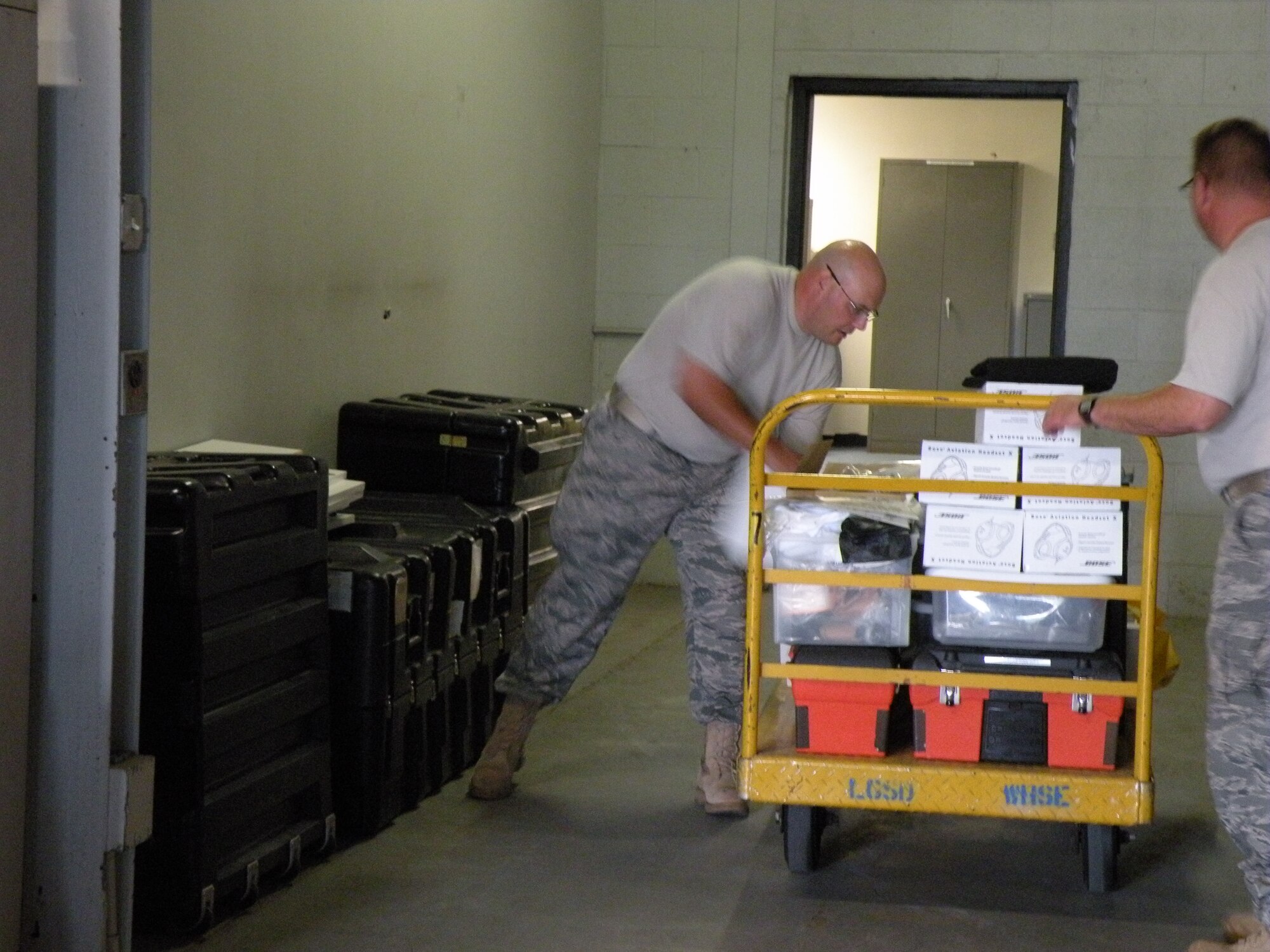 Chief Master Sgt. Steven L. Seaha, 103rd Operations Group Superintendent, works with Maj. Glenn Sherman, 103rd Air and Space Operations Squadron, as they unload the 118th Airlift Asquadron’s life support equipment into temporary storage within the 103rd Air and Space Operations Group’s administrative building at Bradley Air National Guard Base, East Granby, Conn. Aug. 26, 2010. The equipment was moved to make way for construction efforts. (U.S. Air Force photo by Staff Sgt. Hope Morris)