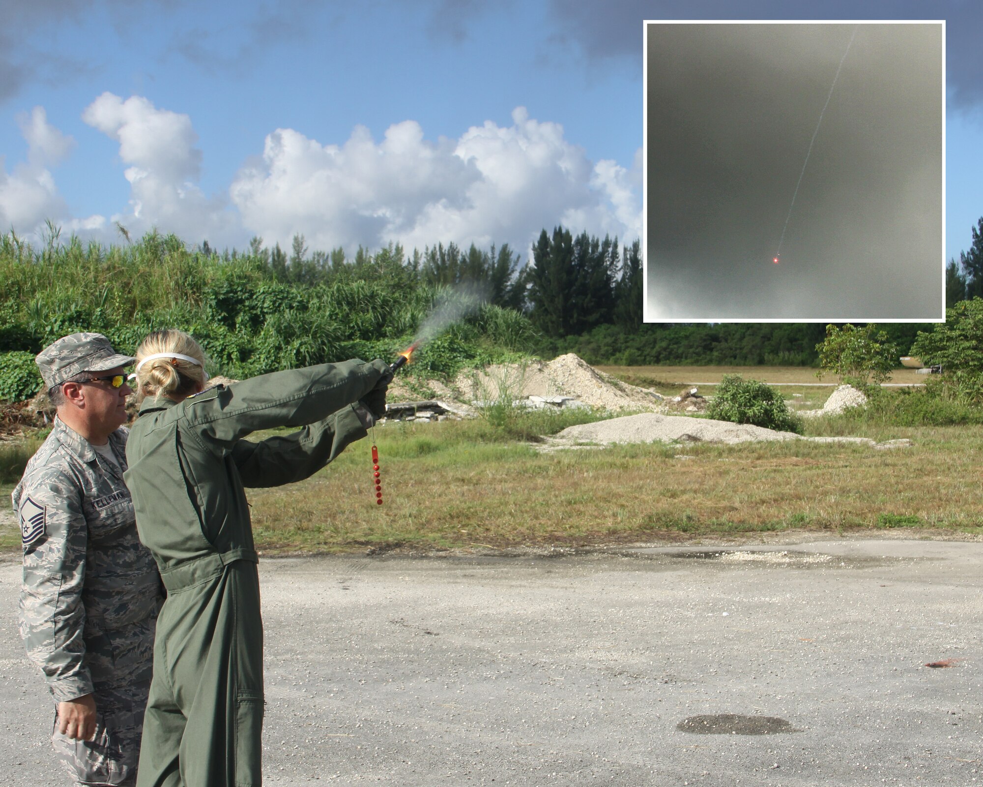 Master Sgt. Bill Kellerman, 482nd Operations Support Squadron Aircrew Flight Equipment, instructs Maj. Julie Moore, 93rd Fighter Squadron Mako pilot, in the use of a gyrojet flare gun during Combat Survival Training at Homestead Air Reserve Base, Sep 11. [inset: The flare fired by Maj. Moore falls towards the earth.] The training was part of a 2-day event that included signalling, survival kit familiarization, land navigation and land and water survival training. (U.S. Air Force photo illlustration/ Tech. Sgt. Ian Carrier)