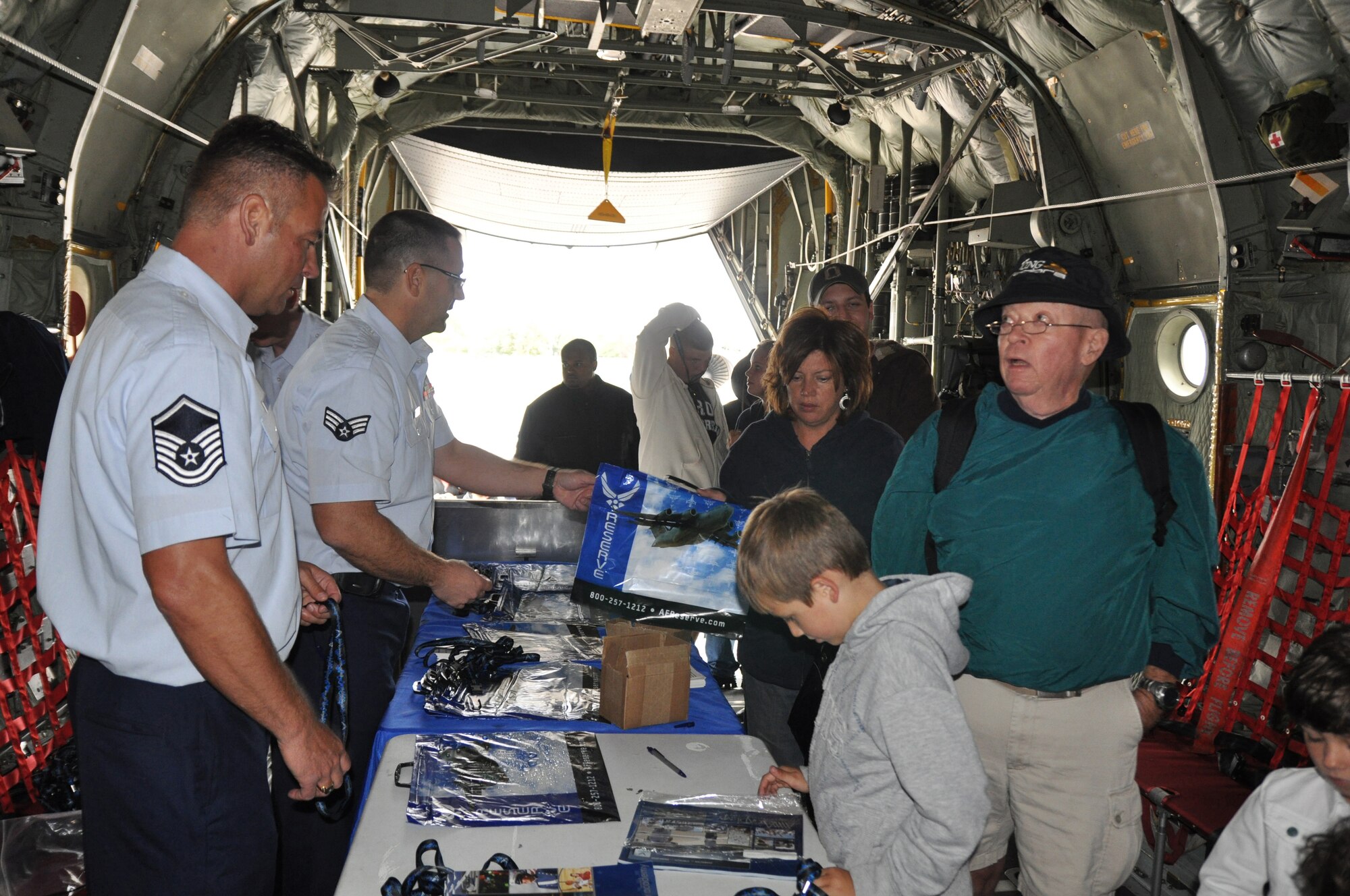 CLEVELAND, Ohio—U.S. Air Force Reserve Master Sgt. Brian A. Starr, a member of the 910th Mission Support Group, helps Air Force Reserve recruiters hand out materials to Cleveland air show participants touring inside a C-130 Hercules September 4 at Burke Lakefront Airport. U.S. Air Force Photo by Maj. Brent Davis    