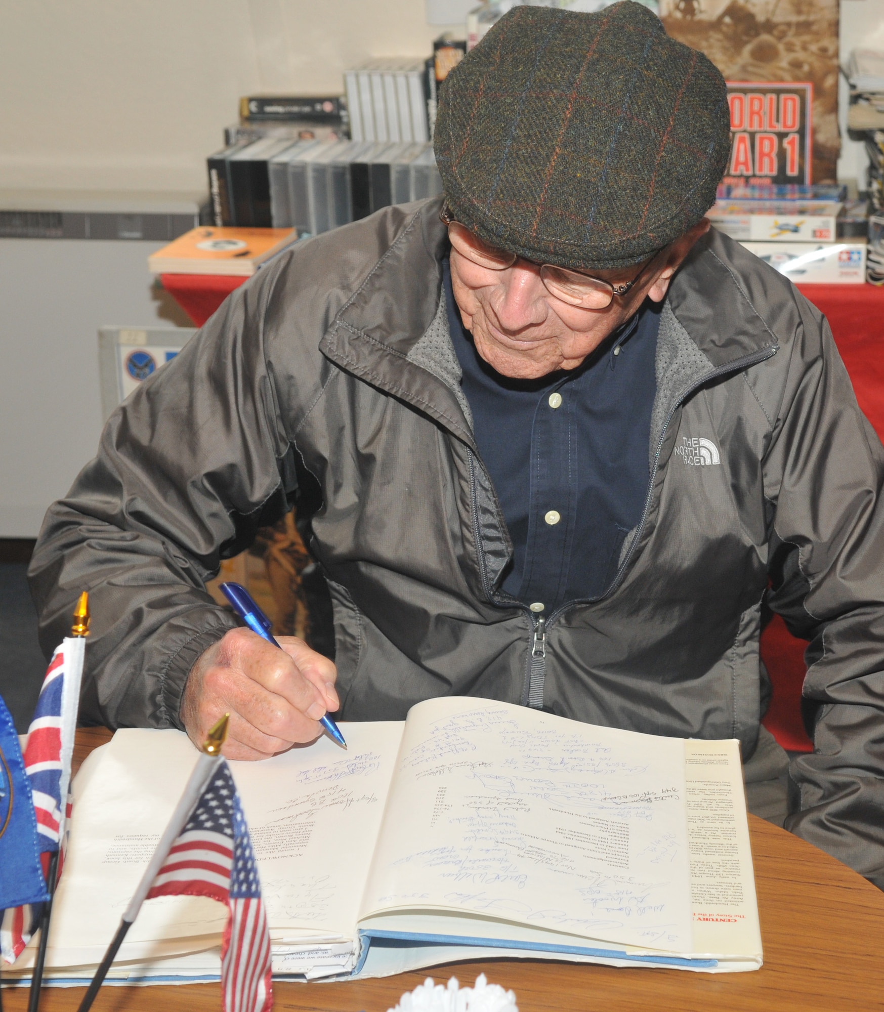 Capt. (ret.) Robert Shoens, pilot of the B-17 'Our Gal Sal,' signs an autograph during his tour of Thorpe Abbotts museum Sept. 11, 2010. This was his fifth return to Thorpe Abbotts since being discharged from the Army Air Force in 1945. (U.S. Air Force photo/Tech. Sgt. Kevin Wallace)