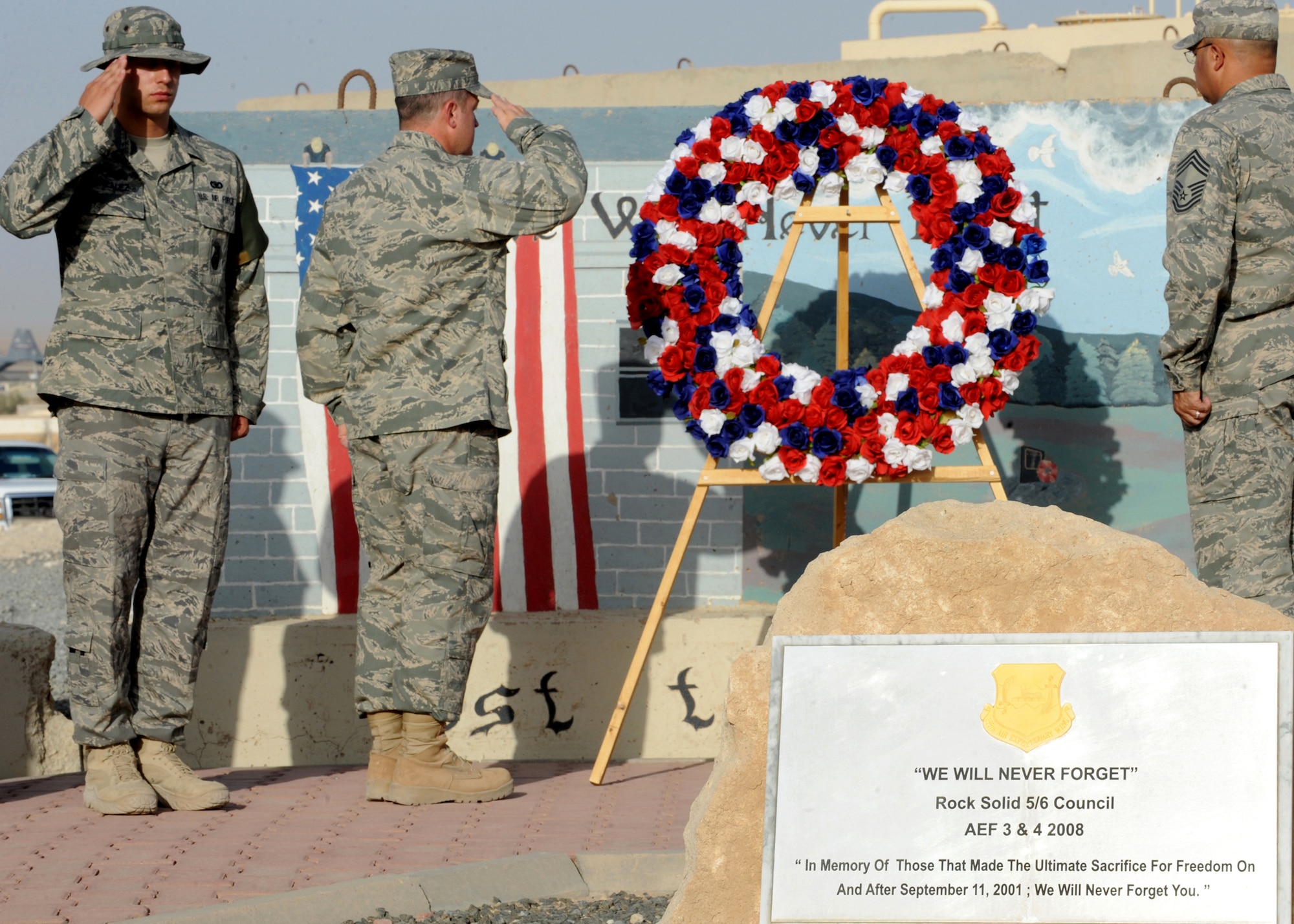 SOUTHWEST ASIA - Airman 1st Class Juan Gonzalez of the 386th Expeditionary Security Forces Squadron (left); 386 Air Expeditionary Wing vice commander Col. Michael B. Katka (center); and Chief Master Sgt. Anthony Cleveland, 386th Expeditionary Mission Support Squadron, salute as Taps is played during a 9/11 wreath-laying ceremony at an undisclosed air base here Sept. 11, 2010. The service was held in tribute to the nearly 3,000 men and women who lost their lives during terrorist attacks on the United States on Sept. 11, 2001. (U.S. Air Force photo by Senior Airman Laura Turner)