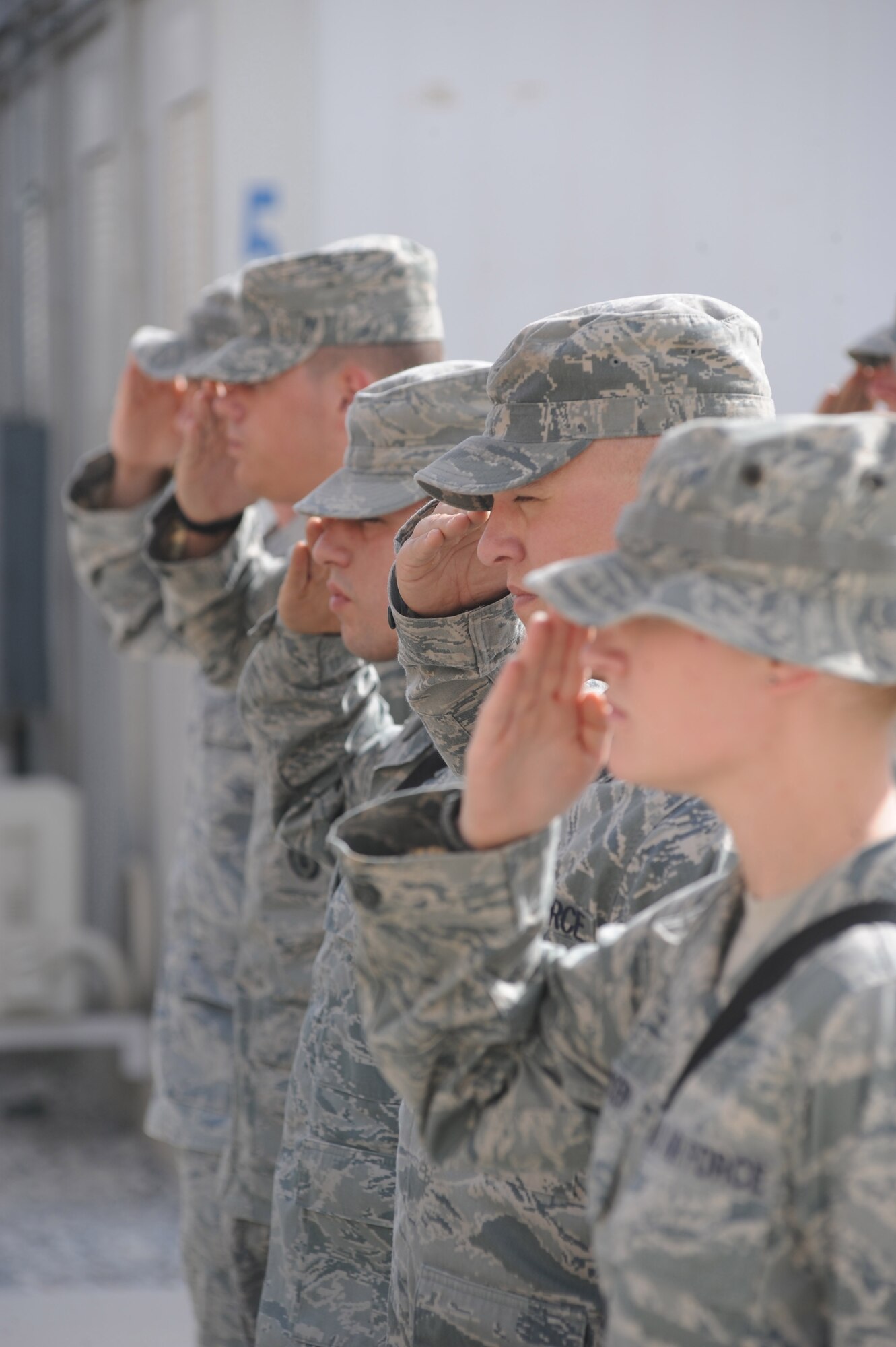Airmen of the 451st Air Expeditionary Wing render a salute during the lowering of the American flag at the 9/11 memorial ceremony Sept. 11, 2010, at Kandahar Airfield, Afghanistan.  This is the ninth anniversary of the day 2,998 individuals perished during a terrorist attack. (U.S. Air Force photo by Tech. Sgt. Chad Chisholm/Released)