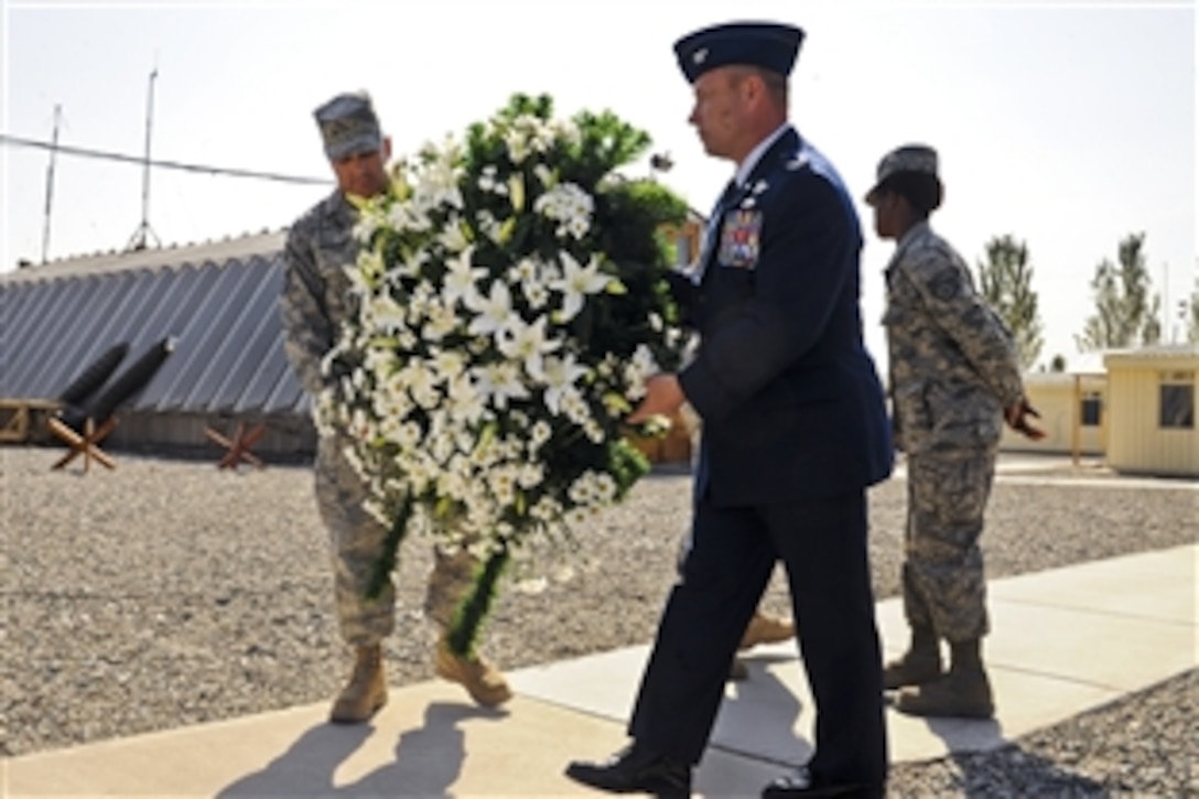 U.S. Air Force Col. Brian Brandner, right, and Chief Master Sgt. Anthony Amador prepare a wreath for display at the Transit Center in Manas, Kyrgyzstan, Sept. 11, 2010, during a ceremony honoring about 3,000 people who died in the terrorist attacks, Sept. 11, 2001. Brandner is the 376th Air Expeditionary Wing vice commander and Amador is the 376th Expeditionary Mission Support Group superintendent.