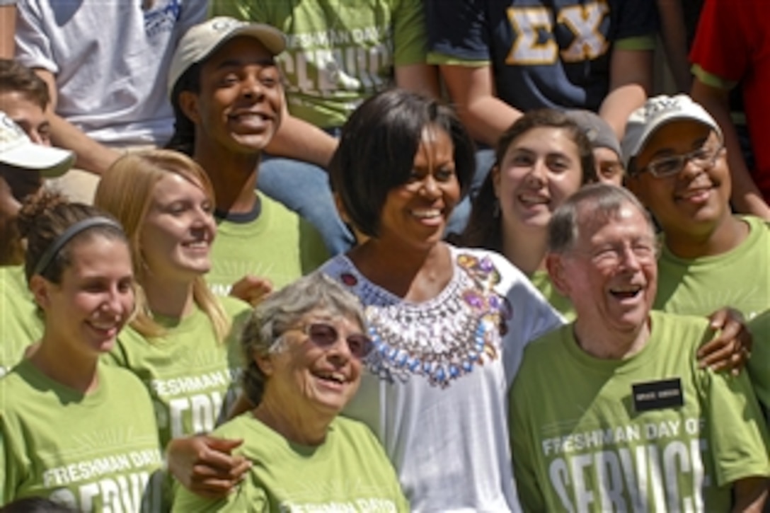 First Lady Michelle Obama poses for a picture with volunteers helping with a community service project at the Vinson Hall Retirement Community in McLean, Va., Sept. 11, 2010. About 150 vounteers pitched in on renovation projects for the community's residents, who include World War II and Vietnam War veterans. The first lady is flanked by two of those residents. 