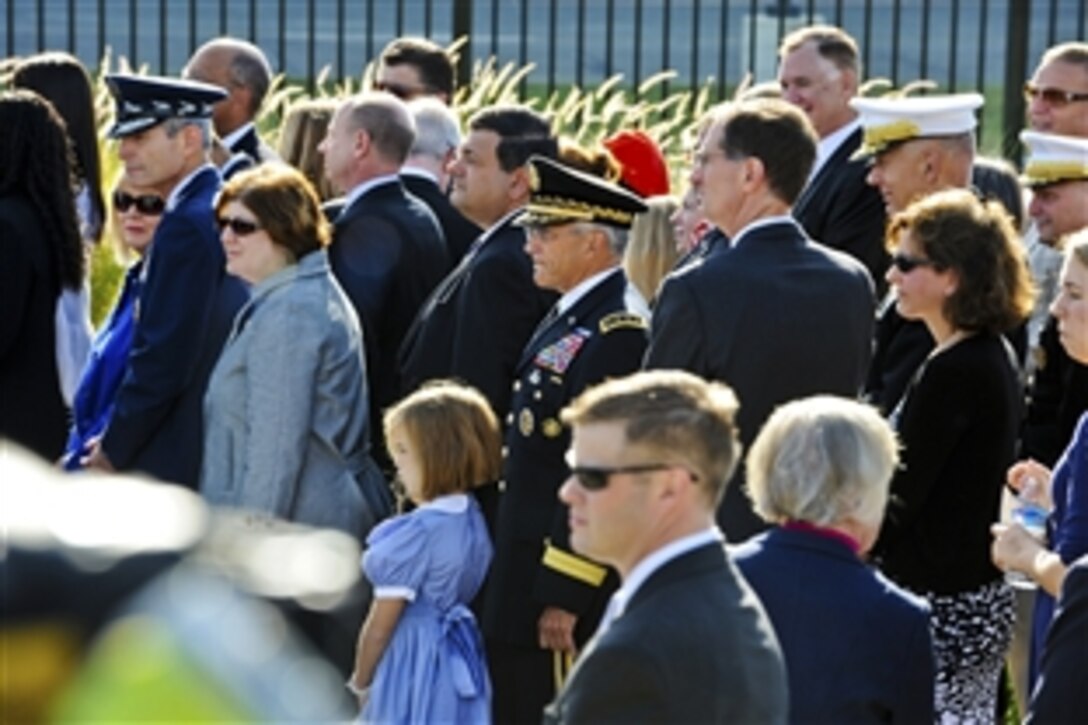 Senior Defense Department officials stand with the families of the those killed at the Pentagon on Sept. 11, 2001, as they listen to the remarks of President Barack Obama during a memorial ceremony at the Pentagon Memorial, Sept. 11, 2010. The ceremony marked the ninth anniversary of the terrorist attack that killed 184 people near this spot in 2001.   