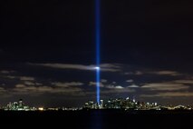 A light display shines from where the World Trade Center used to be, New York, Sept. 11. The two beams of light are illuminated each year on the anniversary of the 9/11 attacks. Ronald Bucca, a New York fire marshal, died on in the attack. On the ninth anniversary of his death his family was presented with a flag from the former Iraq detention facility bearing his name. (Official Marine Corps photo by Sgt. Randall A. Clinton / RELEASED)