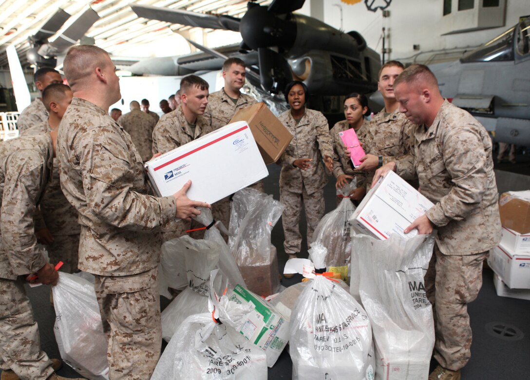 Command Element Marines with 26th Marine Expeditionary Unit organize and separate mail in the hangar bay during their first mail call aboard USS Kearsarge in the Mediterranean Sea, Sept. 12, 2010.  Care packages and hand-written mail are a big part of increasing moral and just one way for family and friends to stay in touch with deployed Marines.