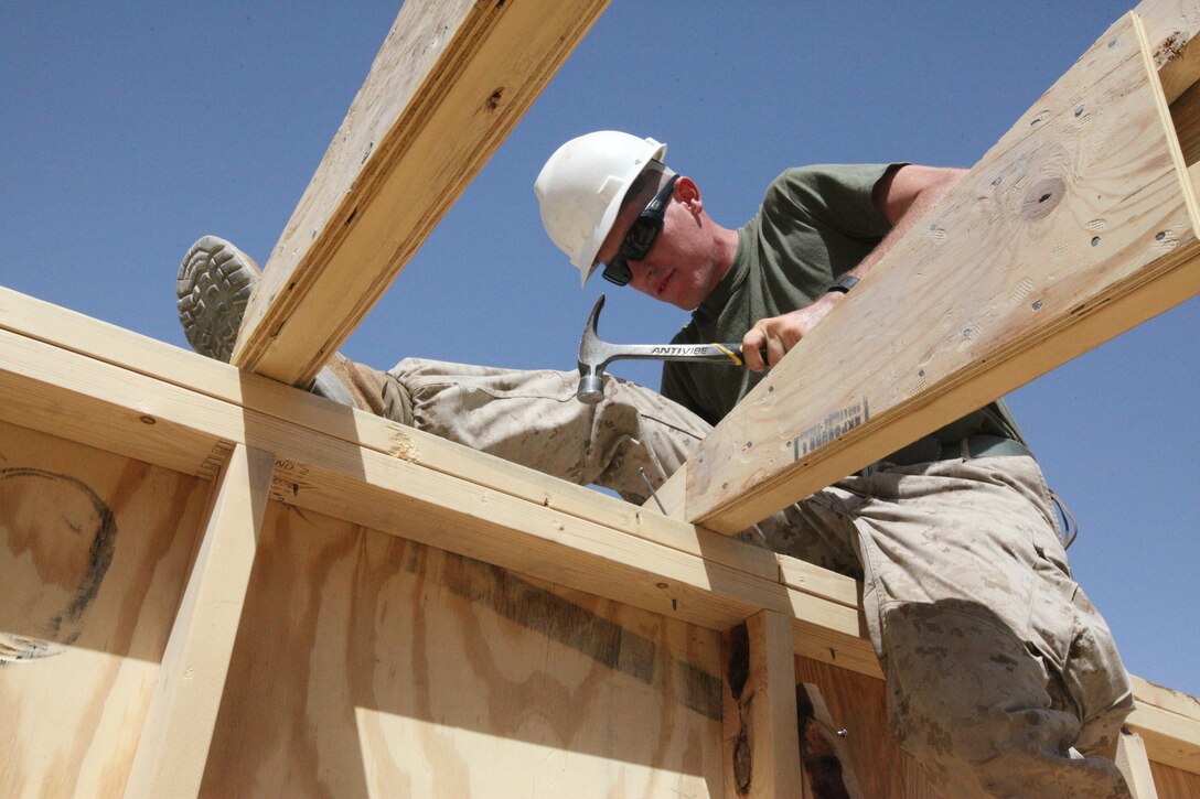 Lance Cpl. Dwason E. Griffith, a combat engineer with Alpha Company, 9th Engineer Support Battalion, 1st Marine Logistics Group (Forward), nails an A-frame to a wall, Sept. 12. Since their arrival on the FOB, Sept. 2, engineers from 9th ESB have been building structures to improve living conditions and security.