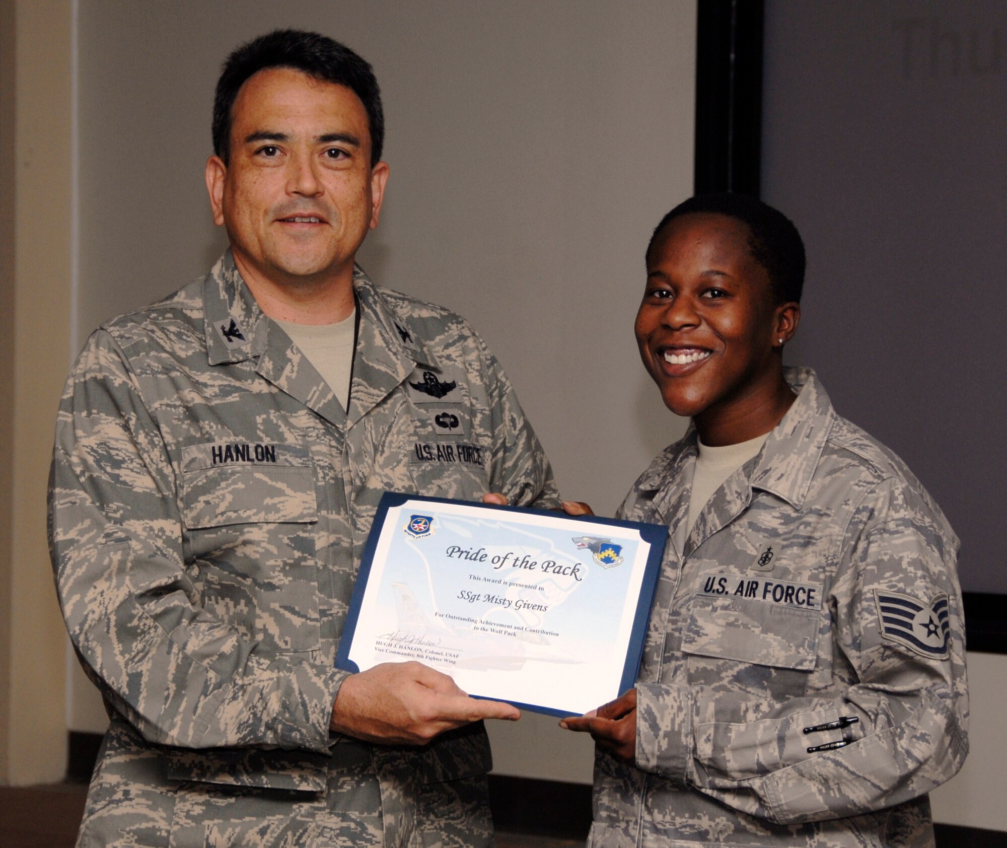 KUNSAN AIR BASE, Republic of Korea -- Col. Hugh Hanlon, 8th Fighter Wing vice commander, presents a Pride of the Pack award Sept. 9 to Staff Sgt. Misty Givens, 8th Medical Support Squadron NCO in charge of information management. (U.S. Air Force photo/Staff Sgt. Amanda Savannah)