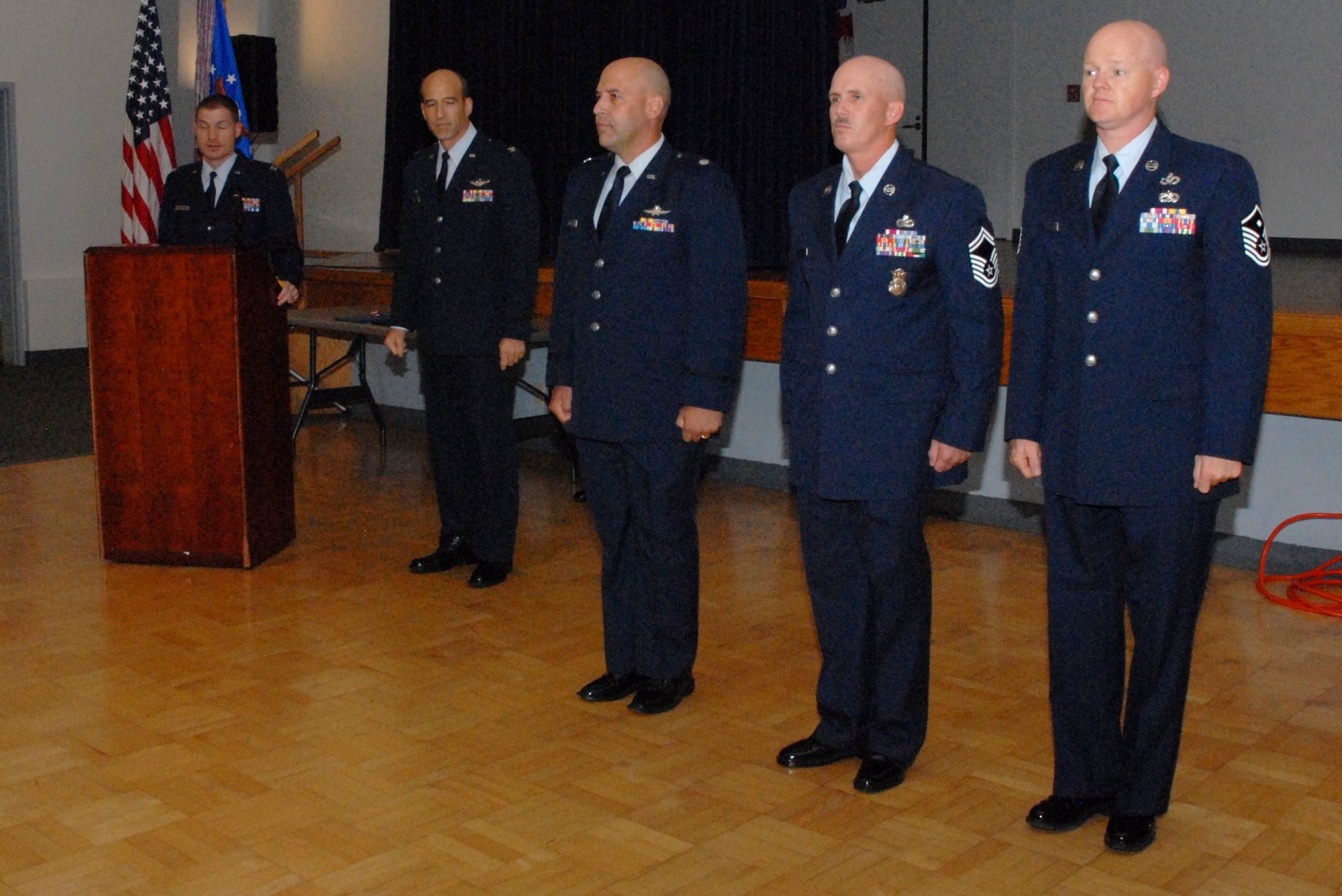 Col. Jeffrey Mineo, 940th Wing commander, presents awards to Lt. Col. Bradley Stoffolano with the 713th Combat Operations Squadron, Senior Master Sgt. Daniel Fode, 940th Security Forces Squadron, and Master Sgt. Daniel Fisher, 50th Intelligence Squadron first sergeant, during commander's call, Sept. 11, at the Community Activity Center, Beale Air Force Base, Calif. (U.S. Air Force photo/Tech. Sgt. Kenneth McCann)

