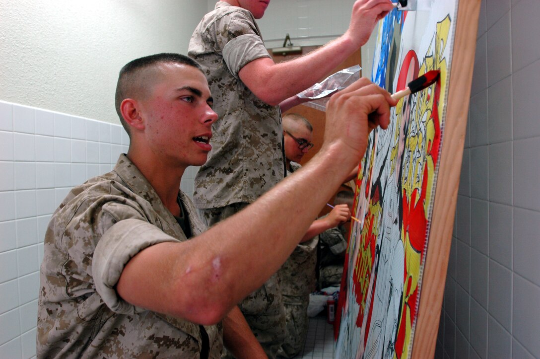 Pvt. Ben W. Reed, Platoon 2128, Company F, helps his fellow Marines paint a gift for their drill instructors here, Sept. 13. The gift is a range flag that is designed around the drill instructors and their platoon, and is given prior to graduation.