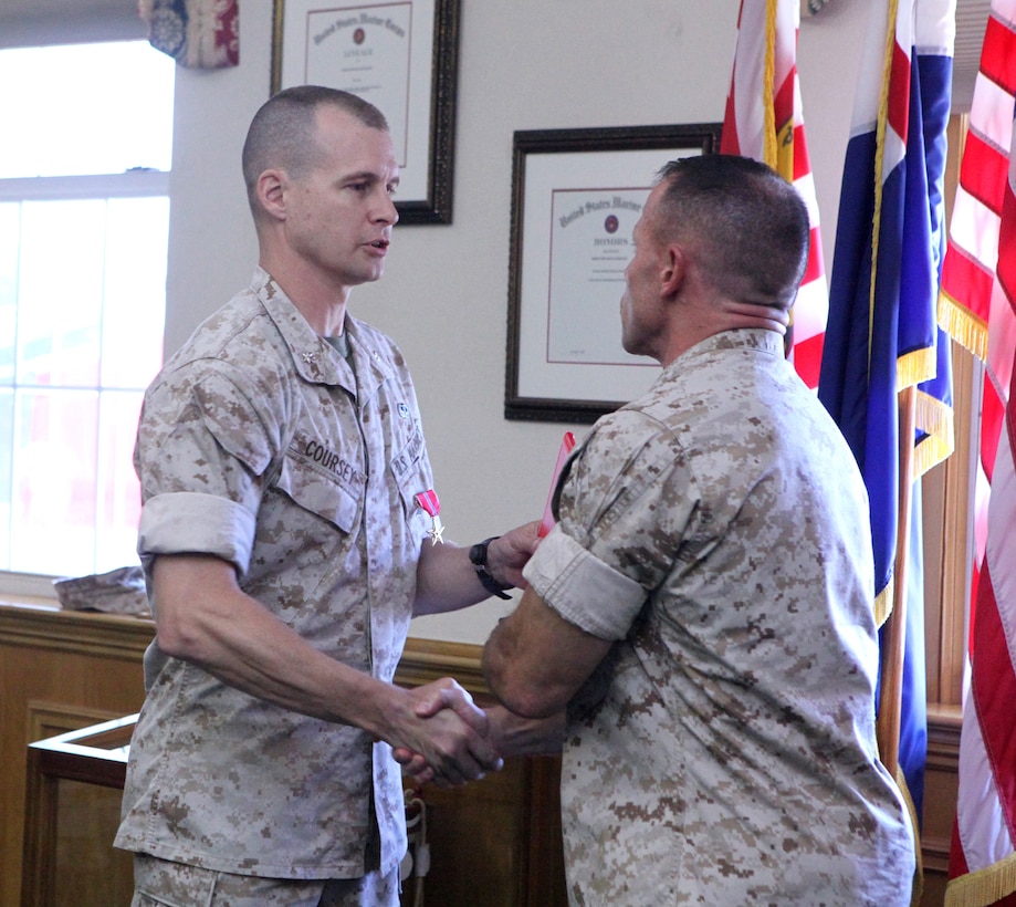 Lt. Col. Guy R. Coursey (left), the installations and environment operations officer with Installations and Environment Department, Marine Corps Base Camp Lejeune, shakes hands with Col. Daniel J. Lecce (right), commanding officer of MCB Camp Lejeune, after receiving the Bronze Star medal during a ceremony at John A. Lejeune Hall aboard the base, Sept. 13.  Coursey, an Eagle River, Alaska, native, received the award for his leadership and professionalism while deployed in support of Operation Enduring Freedom.