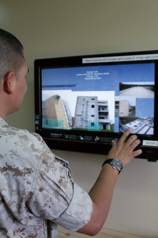 Sgt. Nicholas Miller, operations chief and range warden supervisor with Marine Corps Base Camp Butler Range Detachment on Camp Hansen, views the new information kiosk at range control, Sept. 14. The kiosk, which simplifies the process of viewing ranges and planning training, was installed last month.