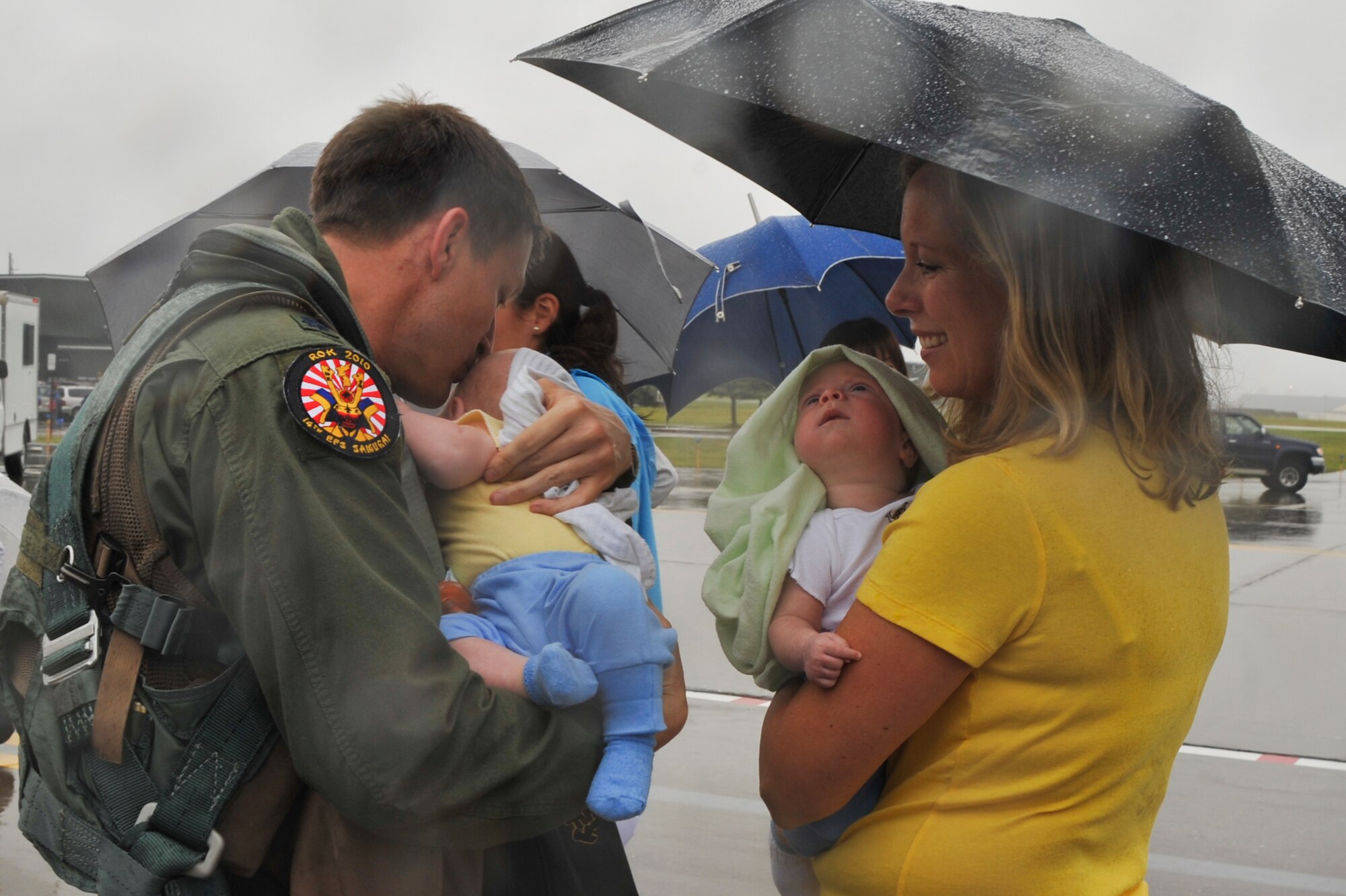 U.S. Air Force Lt. Col. Aaron Steffens, 14th Fighter Squadron commander, kisses one of his twin sons Sept 11, 2010 as his wife; Jenn Steffens, greets her husband home from a six-month deployment to Kunsan Air Base, Korea. (U.S. Air Force photo/Tech. Sgt. Russell McBride/Released)