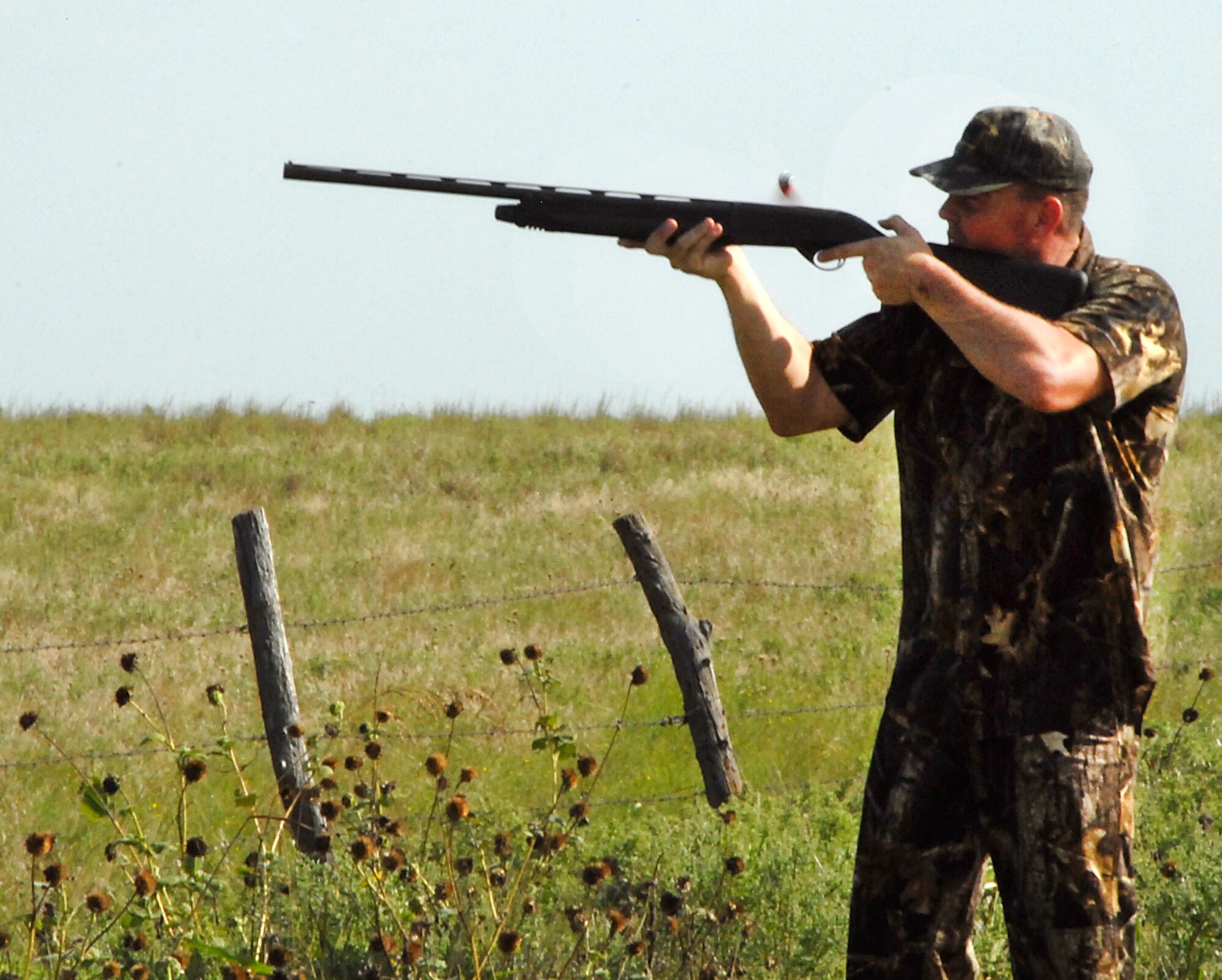 An active-duty servicemember fires at a dove during the 6th Annual Clay County Dove Salute Sept. 11 at the Birdwell-Clark Ranch in Henrietta, Texas.  Deborah Clark and Emry Birdwell, hosts of the event, started it as a way to thank military members for their service.  (U.S. Air Force photo/Harry Tonemah)