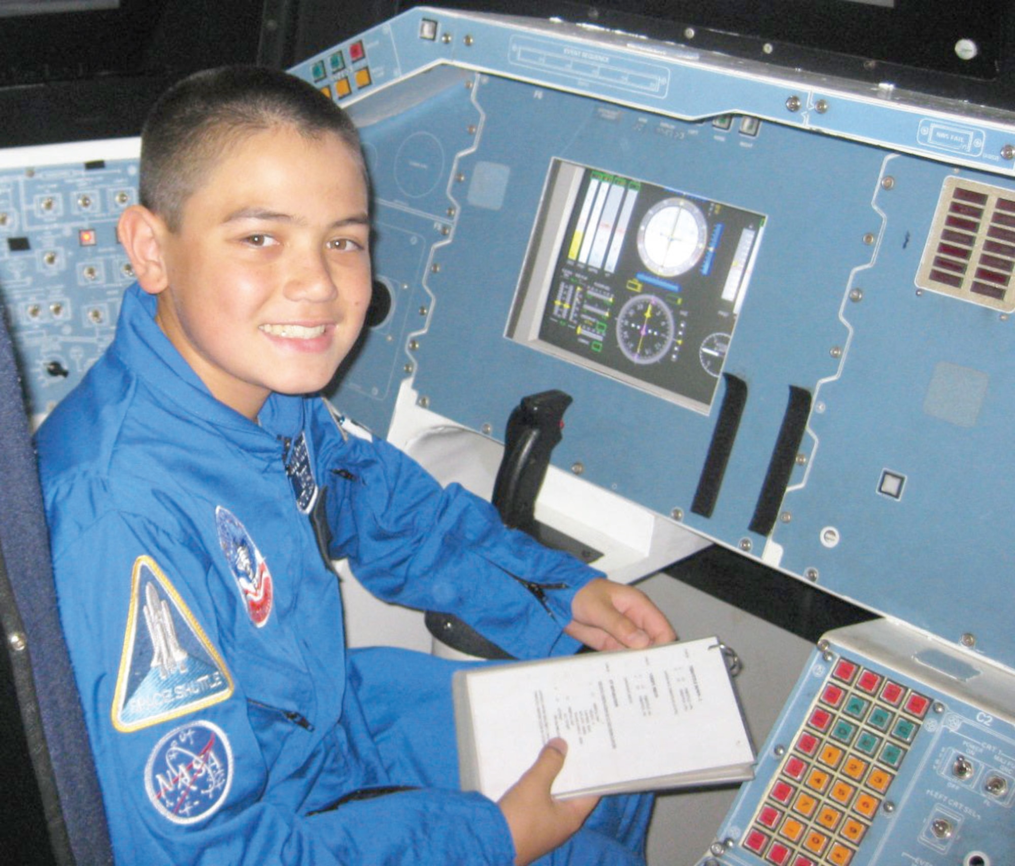 Charles Macleod reviews a checklist in the space shuttle simulator in Huntsville, Ala.
Charles is a 9th grader from Redlands, Calif., who was selected to attend Air Force Space Camp this year.  (U.S. Air Force photo courtesy of Charles Macleod)
