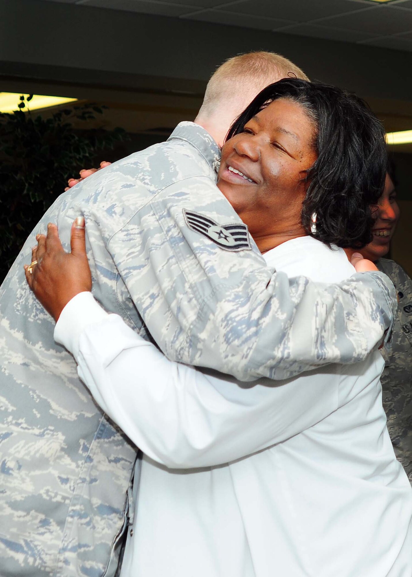 ALTUS AIR FORCE BASE, Okla. -- Staff Sgt. Adam Hills embraces Rosa Jenkins, 97th Medial Group, Sept. 13. Jenkins and her grandson were involved in an accident on Highway 62 Sept. 8. Staff Sgt. Hills dressed her injury while Airmen 1st Class Arryawna Saldana directed traffic and Airman 1st Class Bryan Foley took her grandson to safety. (U.S. Air Force photo by Senior Airman Leandra D. Hernandez/Released 97th Air Mobility Wing Public Affairs)