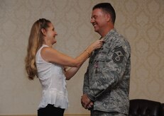 Chief Master Sgt. Mike Ivey proudly watches his wife, Carlee Ivey pin his retirement pin to his lapel during his retirement ceremony at the Charleston Club on Joint Base Charleston, S.C., Aug, 20, 2010. Chief Ivey will officially retire in November after 23 years of dedicated service. Chief Ivey is the 628th Air Base Wing command chief. (U.S. Air Force Photo/Airman1st Class Lauren Main)