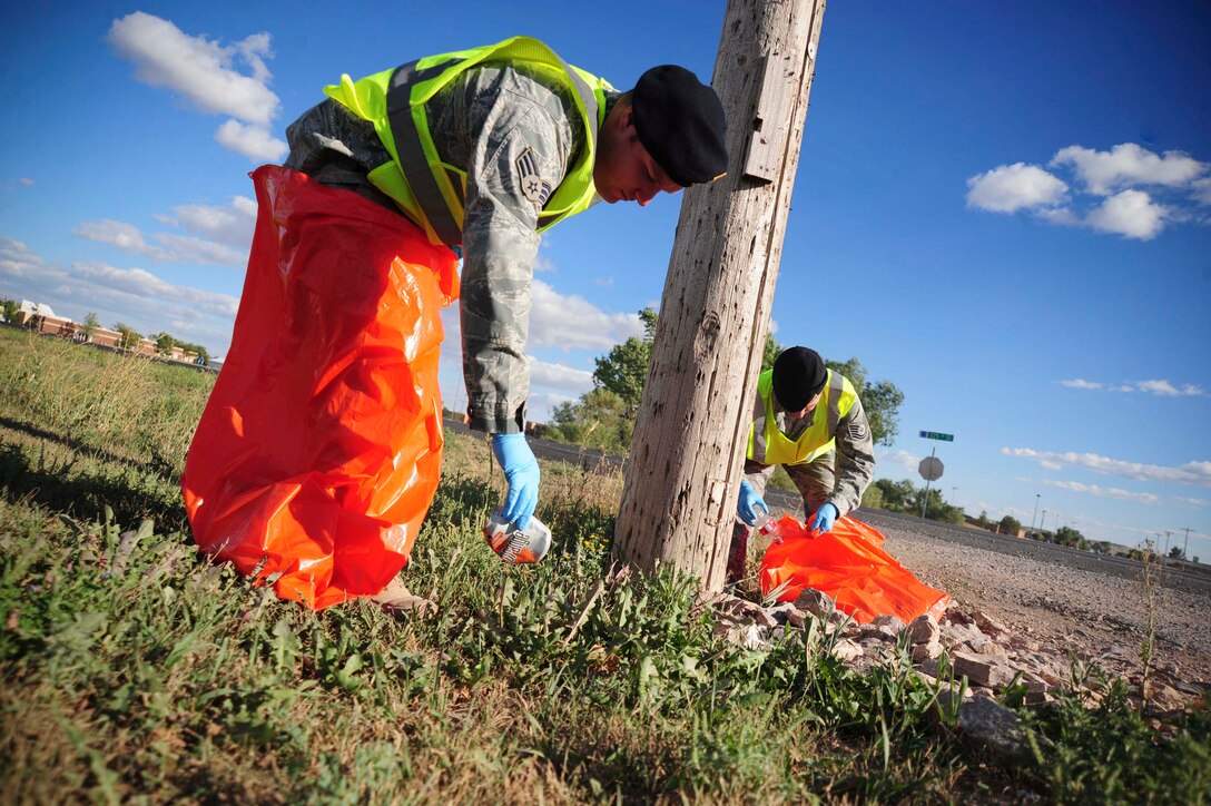 ELLSWORTH AIR FORCE BASE S.D. – (Front) Senior Airman Alexander Mendes, 28th Security Forces Squadron supply NCO in-charge, and Tech. Sgt. Ryan Sobecki, 28th SFS unit deployment manager NCO in-charge pick up trash, Sept. 2. The logistics flight plans to get more of their squadron involved with cleanup by adopting more ground to clean. (U.S. Air Force photo/Senior Airman Corey Hook)