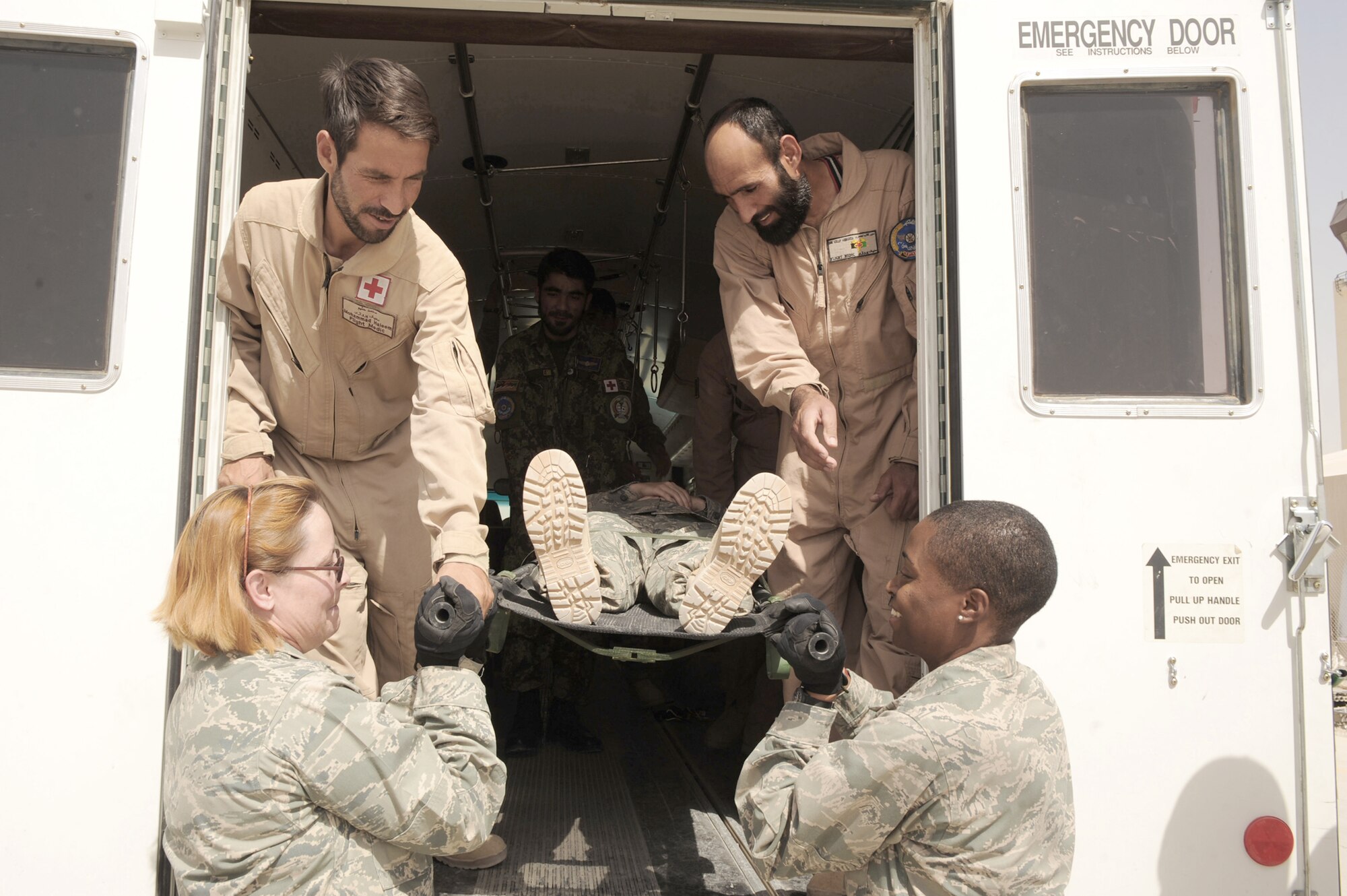 Afghan Air Force flight medics transfer a simulated patient from an ambulance to members of the 451st Expeditionary Aeromedical Evacuation Squadron Contingency Aeromedical Staging Facility during an orientation Sept. 8, 2010, at Kandahar Airfield, Afghanistan. (U.S. Air Force photo/Tech. Sgt. Chad Chisholm)