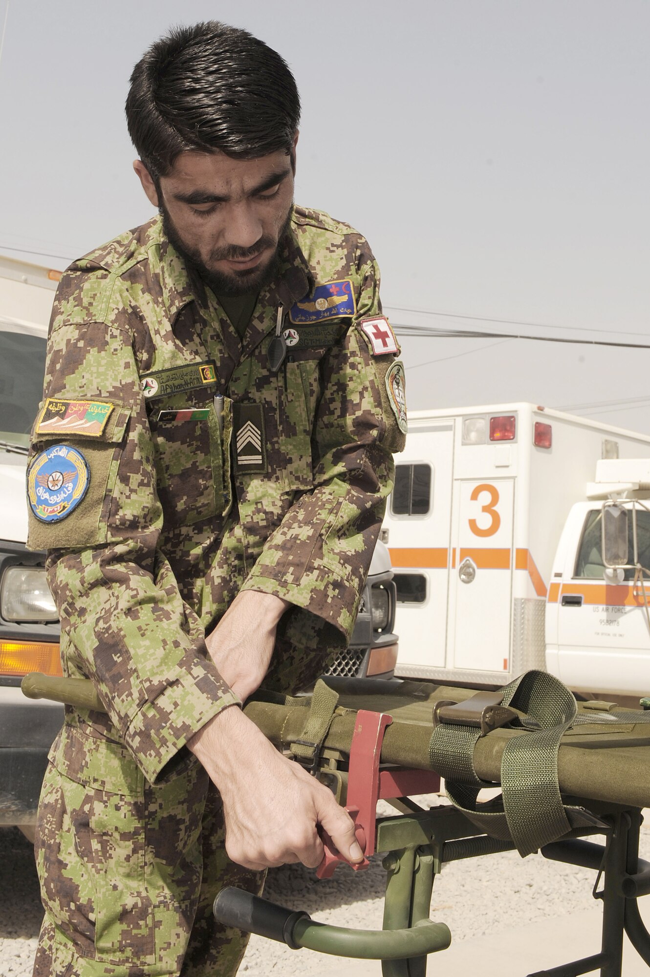 An Afghan flight medic tightens a clamp on a gurney to a patient litter during a patient care concepts orientation Sept. 8, 2010, at Kandahar Airfield, Afghanistan. (U.S. Air Force photo/Tech. Sgt. Chad Chisholm)