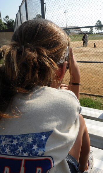 MOODY AIR FORCE BASE, Ga. -- A youth member attending the Kids Deployment Line shades her eyes from the sun to see a military working dog demonstration here Sept. 11. The 23rd Security Forces Squadron provided MWD demonstrations at the softball field across from the Freedom I Fitness Center. (U.S. Air Force photo/Airman 1st Class Benjamin Wiseman)
