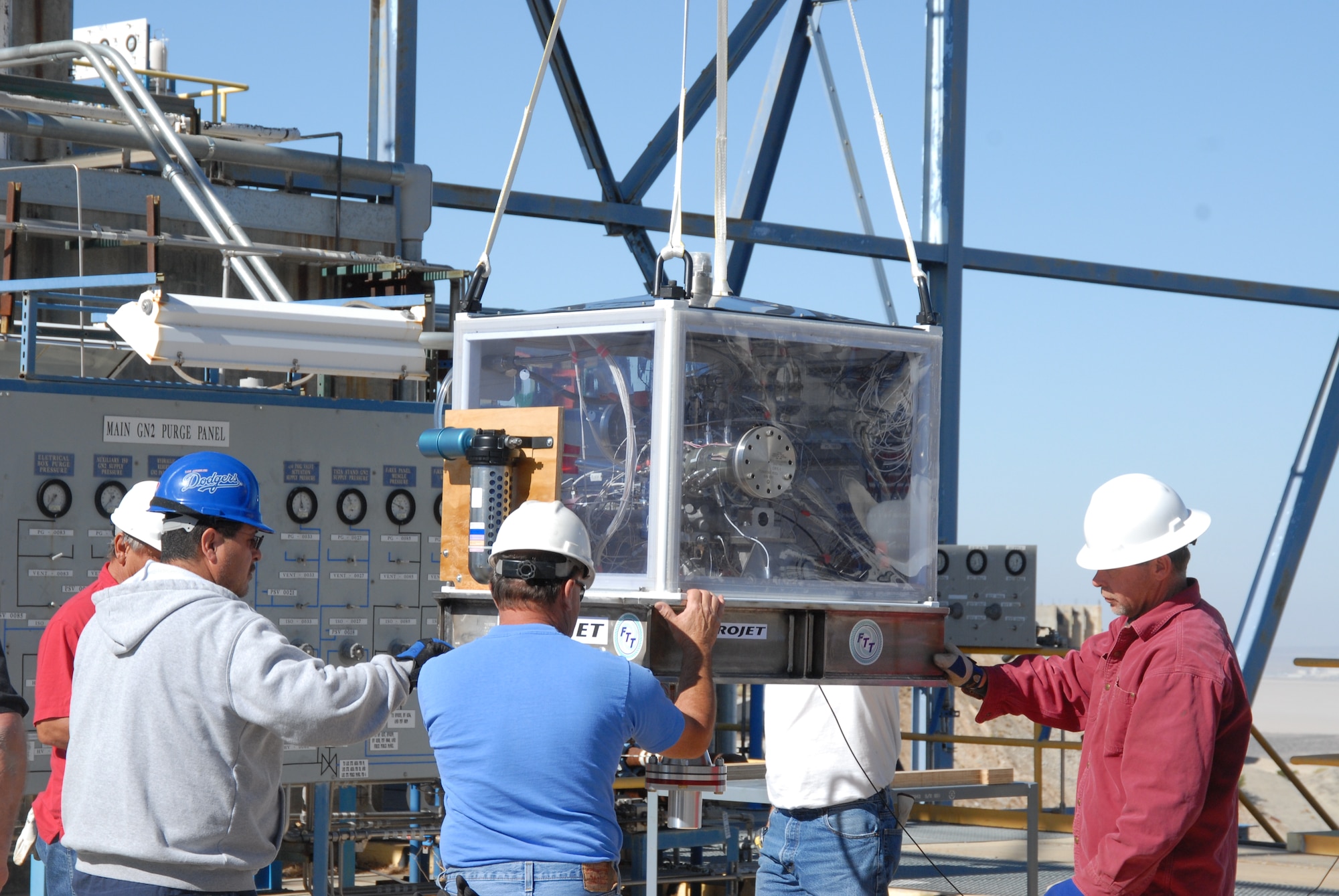 Air Force Research Laboratory workers use a crane to remove a newly delivered Upper Stage Engine Technology turbo pump from its shipping crate.  The USET turbo pump will be connected to AFRL's 2A rocket test stand where it will undergo a series of tests using liquid hydrogen.  (Air Force photo by Kenji Thuloweit)
