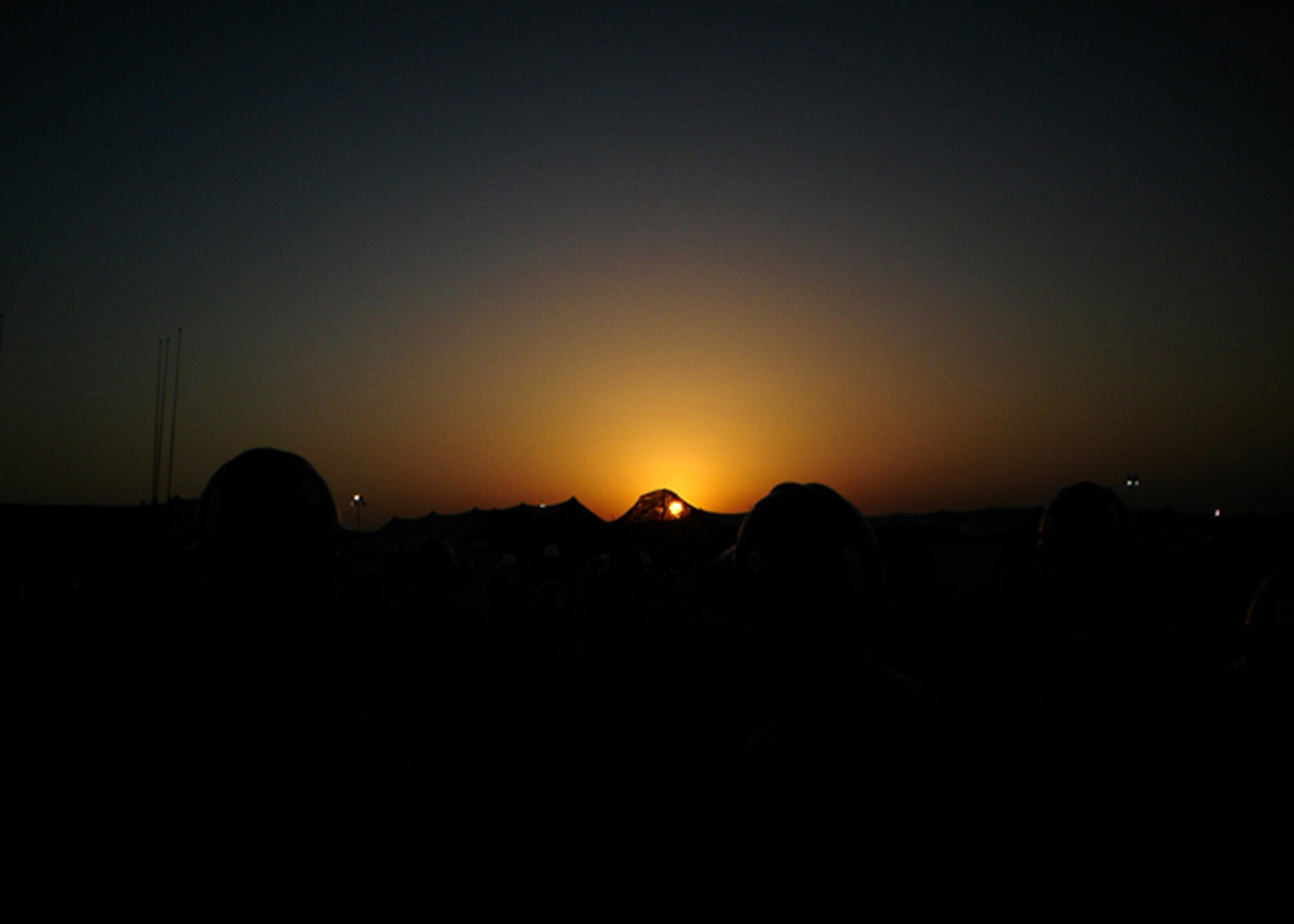 The sun rises over the offices of Navy Construction Battalion 21 (Seabees), September 28, 2006, Camp Arifjan, Kuwait. Seabee members muster every morning for daily instruction in front of the administration offices. (U.S. Air Force photo by Staff Sgt. Joseph McKee) 
