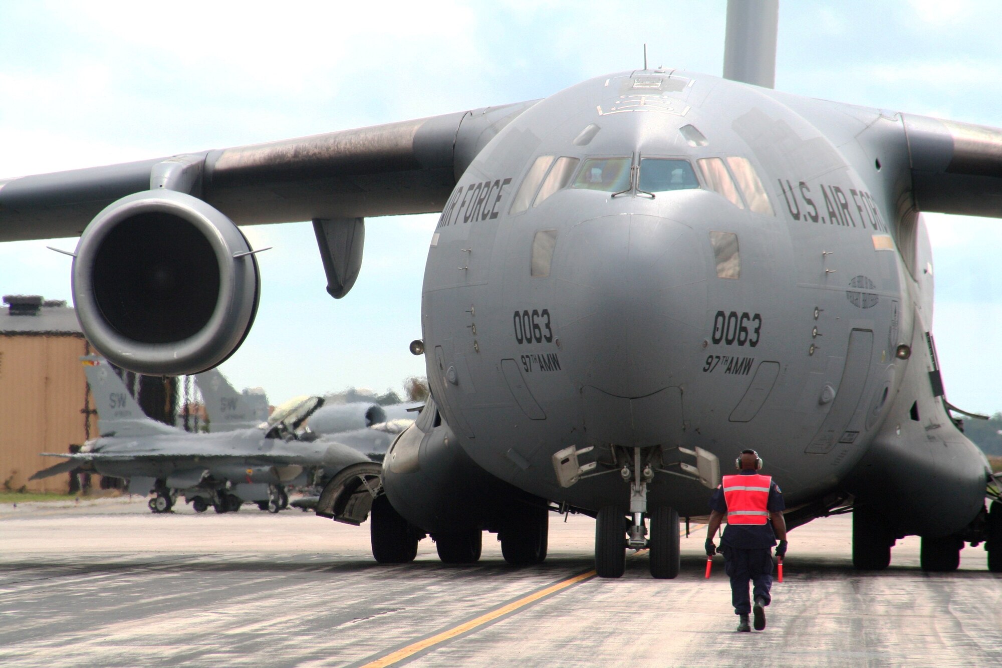 A maintenance Airmen helps guide a C-17 Globemaster III crew from the 97th Air Mobility Wing at Altus Air Force Base, Okla., on the flightline at Scott AFB, Ill., on Sept. 11, 2010. The C-17 and the Airmen who fly and maintain it were on hand to hold an aerial demonstration for the 2010 Airpower Over The Midwest Airshow at Scott AFB. During the two-day airshow, tens of thousands of people attended. The C-17 is the Air Force's and Air Mobility Command's newest airlift aircraft. (U.S. Air Force Photo/Master Sgt. Scott T. Sturkol)