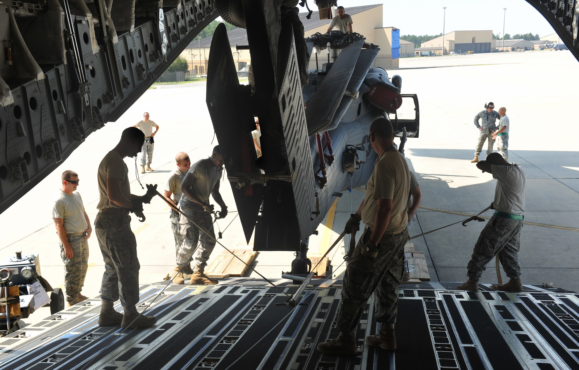MOODY AIR FORCE BASE, Ga. -- Airmen from the 23rd Logistics Readiness Squadron and 41st Helicopter Maintenance Unit adjust and maneuver an HH-60G Pave Hawk so it can be pulled onto the back of a C-17 Globemaster III here Sept. 3. The Airmen used whistles to communicate and determine which way the aircraft needs to be shifted. (U.S. Air Force photo/Airman 1st Class Joshua Green)
