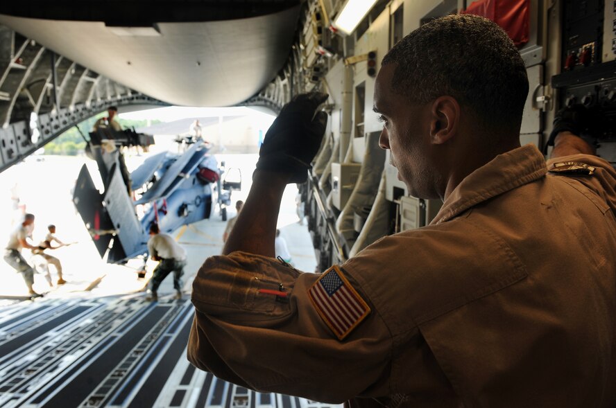 MOODY AIR FORCE BASE, Ga. -- Staff Sgt. Kory Williams, 3rd Airlift Squadron loadmaster from Dover Air Force Base, Del., watches Moody Airmen load up an HH-60G Pave Hawk onto the back of a C-17 Globemaster III here Sept. 3. The HH-60Gs are a part of the “Team Rescue” group that consist of the 38th Rescue Squadron, 41st RQS and 71st RQS, who will be deploying together to Afghanistan. (U.S. Air Force photo/Airman 1st Class Joshua Green)

