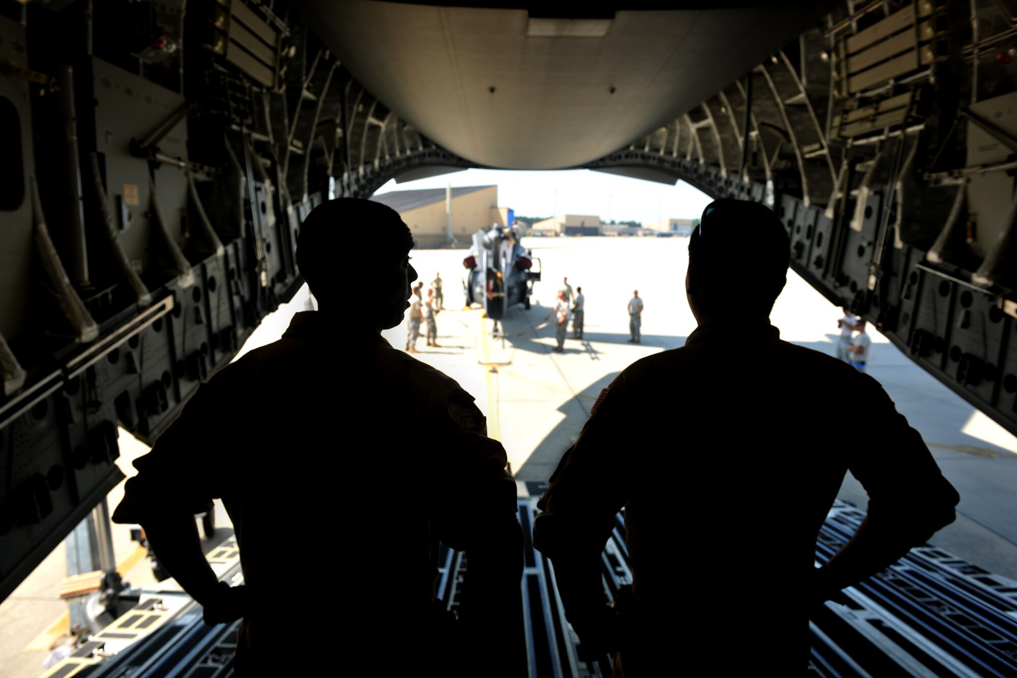 MOODY AIR FORCE BASE, Ga. -- Two Airmen from Dover Air Force Base, Del., wait inside a C-17 Globemaster III while Moody Airmen prepare an HH-60G Pave Hawk for loading here Sept. 3. The HH-60G is being sent overseas for a deployment with members from the 41st Rescue Squadron. (U.S. Air Force photo/Airman 1st Class Joshua Green)
