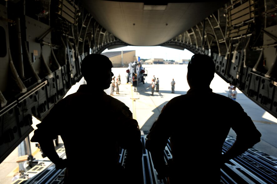 MOODY AIR FORCE BASE, Ga. -- Two Airmen from Dover Air Force Base, Del., wait inside a C-17 Globemaster III while Moody Airmen prepare an HH-60G Pave Hawk for loading here Sept. 3. The HH-60G is being sent overseas for a deployment with members from the 41st Rescue Squadron. (U.S. Air Force photo/Airman 1st Class Joshua Green)

