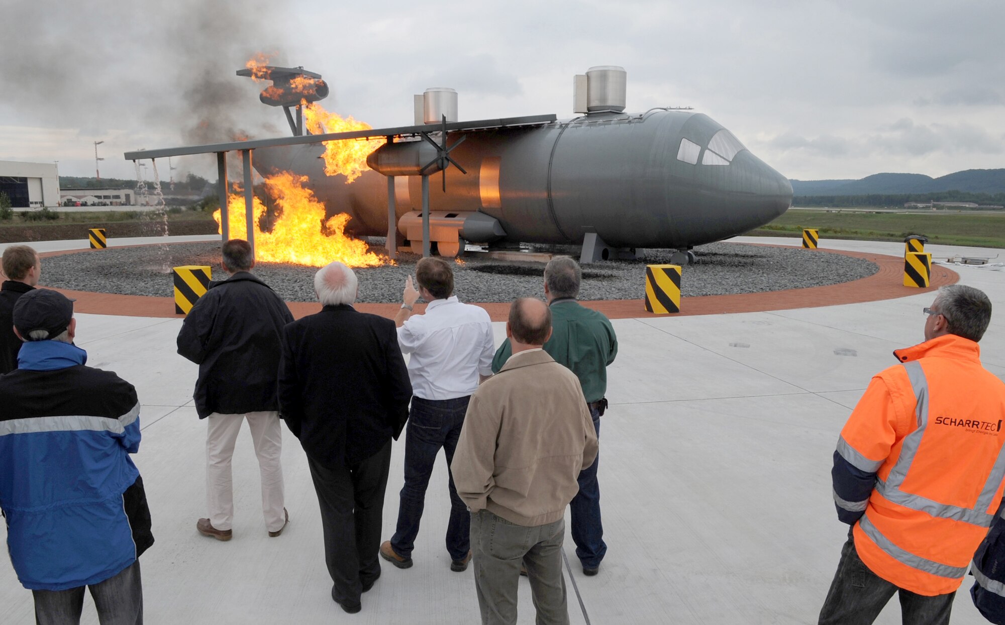 Construction team members and fire trainers view a new aircraft fire training burn site Sept. 9, 2010 at Ramstein Air Base, Germany. The new burn site is the only aircraft training site in Germany and will help train in many aircraft scenarios. (U.S. Air Force photo/Senior Airman Caleb Pierce) 
