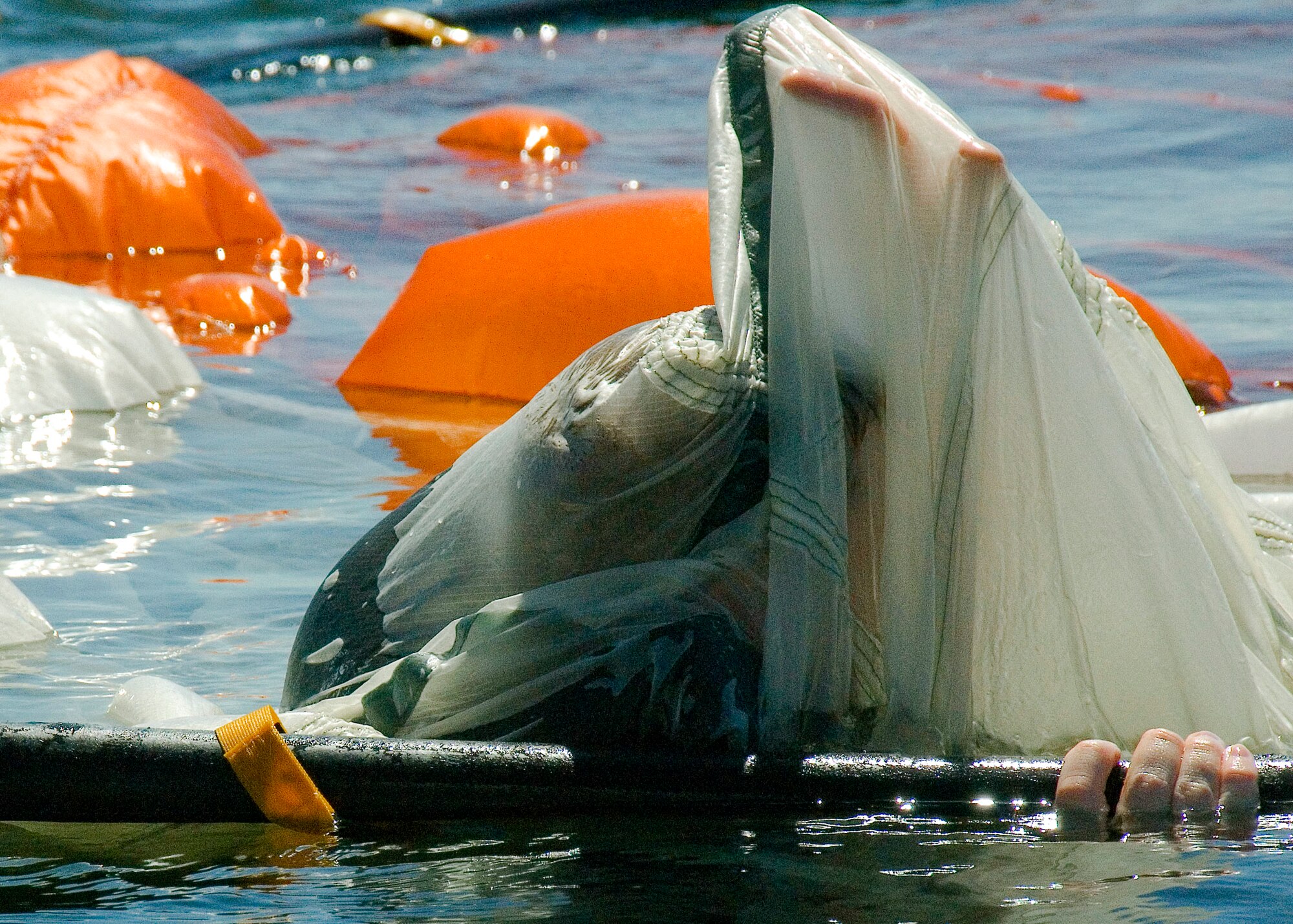 EGLIN AIR FORCE BASE, Fla. -- An aircrew member begins his training trying to escape from under a water parachute trainer Sept. 10, at Post'l Point.  Aircrew members learn to pull hand over hand along the chute's seam to remove the water- logged chute.  More than a dozen aircrew members received the water survival training that day. (U.S. Air Force photo/Staff Sgt. Felicia L. Welch) 