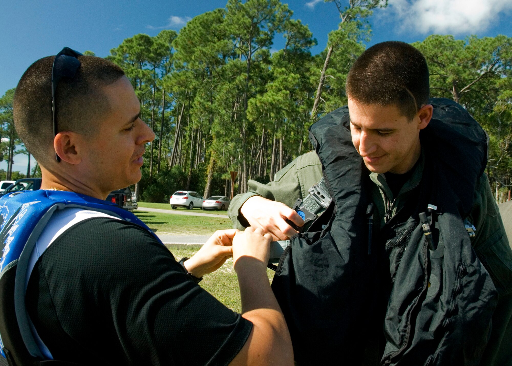 EGLIN AIR FORCE BASE, Fla. -- Tech. Sgt. Maikel Figueroa-Jimenez, 46th Operation Support Squadron Life Support Flight, assists Maj. David Garay, AAC executive officer, Sept. 10, in donning his personal flotation device and chute harness at Post'l Point.  More than a dozen aircrew members received their annual water survival training that day.  (U.S. Air Force photo/Staff Sgt. Felicia L. Welch) 