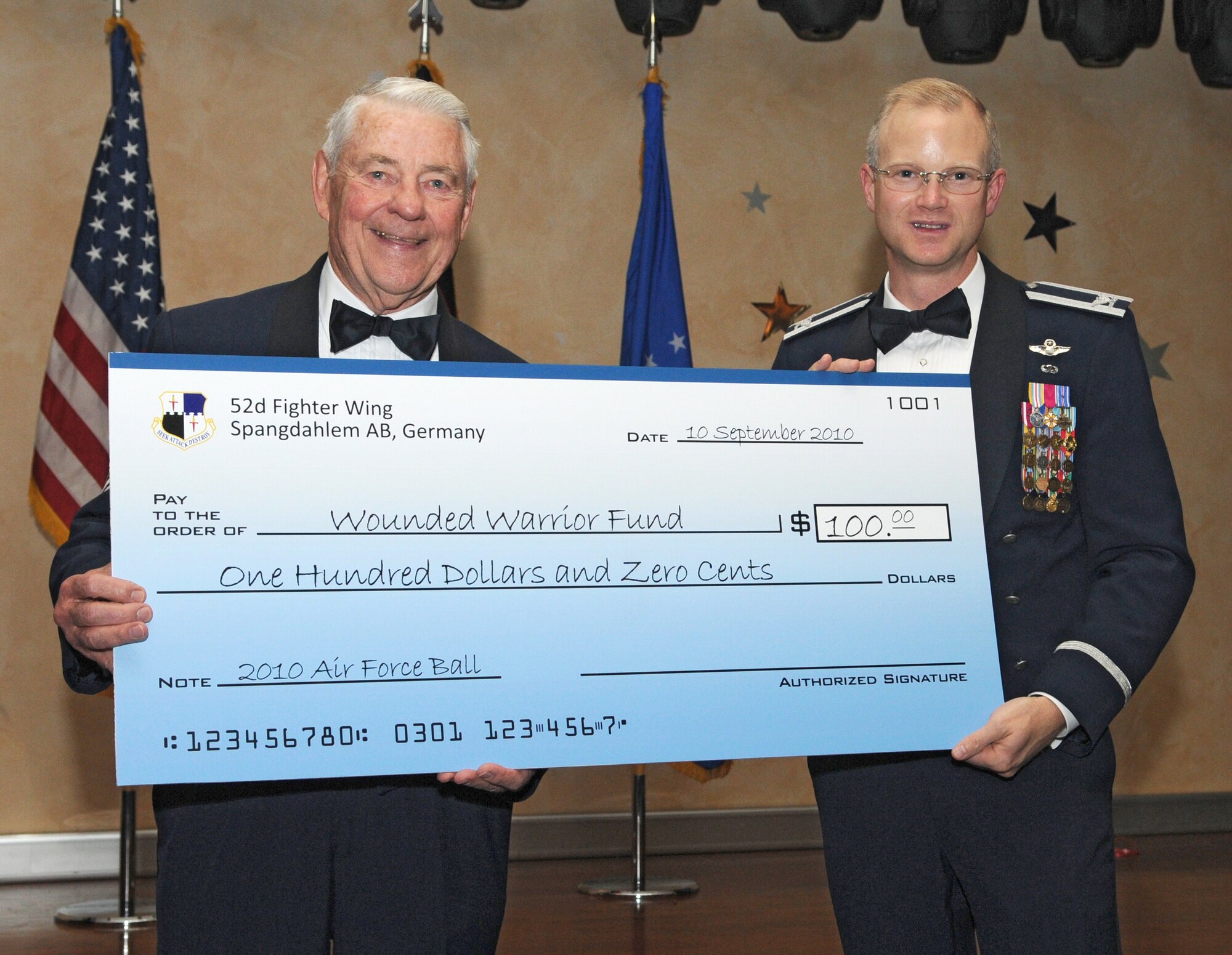 SPANGDAHLEM AIR BASE, Germany – Col. Christopher Weggeman, right, 52nd Fighter Wing commander, presents Robert D. Gaylor, fifth Chief Master Sgt. of the Air Force, a check for $100 donated to the Wounded Warrior Fund in his name during the 2010 Air Force Ball Sept. 10. Chief Gaylor was the keynote speaker during the event, themed, “Remembering our heritage and embracing our future.” (U.S. Air Force photo/Staff Sgt. Benjamin Wilson)