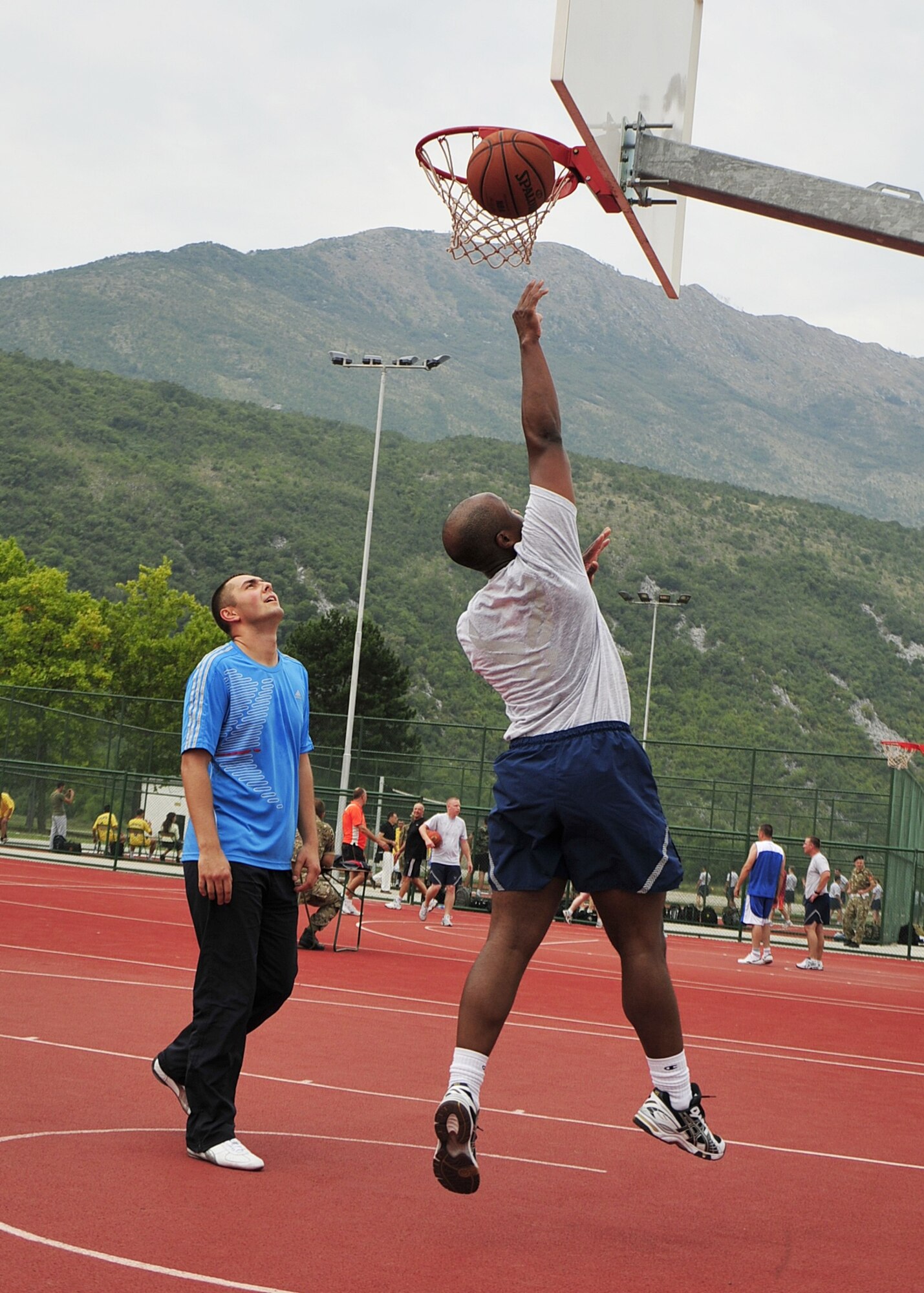 (Left to right) 2nd Lt. Mizon Alexandru of the Moldovan Armed Forces, watches as U.S. Air Force Maj. Ramone Toliver, an emergency physician from the 48th Medical Operations Squadron at RAF Lakenheath, England, shoots a basketball during the MEDCEUR10 sports day at Danilovgrad Army Base, Montenegro, Sept. 12. The day featured friendly competition in multiple sports and opportunities to improve readiness through fitness among military members of 10 nations at the medical training exercise. For more information, go to www.usafe.af.mil/medceur.asp and www.odbrana.gov.me. (U.S. Air Force photo/Airman 1st Class Tiffany Deuel)