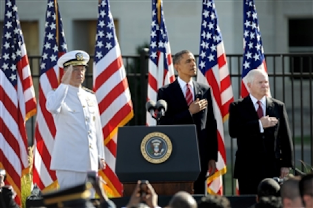 Chairman of the Joint Chiefs of Staff Adm. Mike Mullen (left), President Barack Obama and Secretary of Defense Robert M. Gates (right) stand for the national anthem during a ceremony at the Pentagon Memorial marking the 9th anniversary of the 9/11 terrorist attacks on Sept. 11, 2010.  Also attending the ceremony were family members of those who lost their lives in the attack on the Pentagon.  