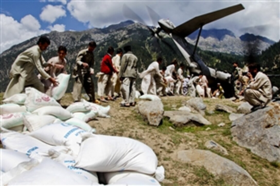 Local Pakistanis unload bags of flour from a CH-53E Super Stallion helicopter in Khyber Pakhtunkhwa, Pakistan, Sept. 10, 2010. The flood has affected nearly 20 million Pakistanis, forcing many from their homes.