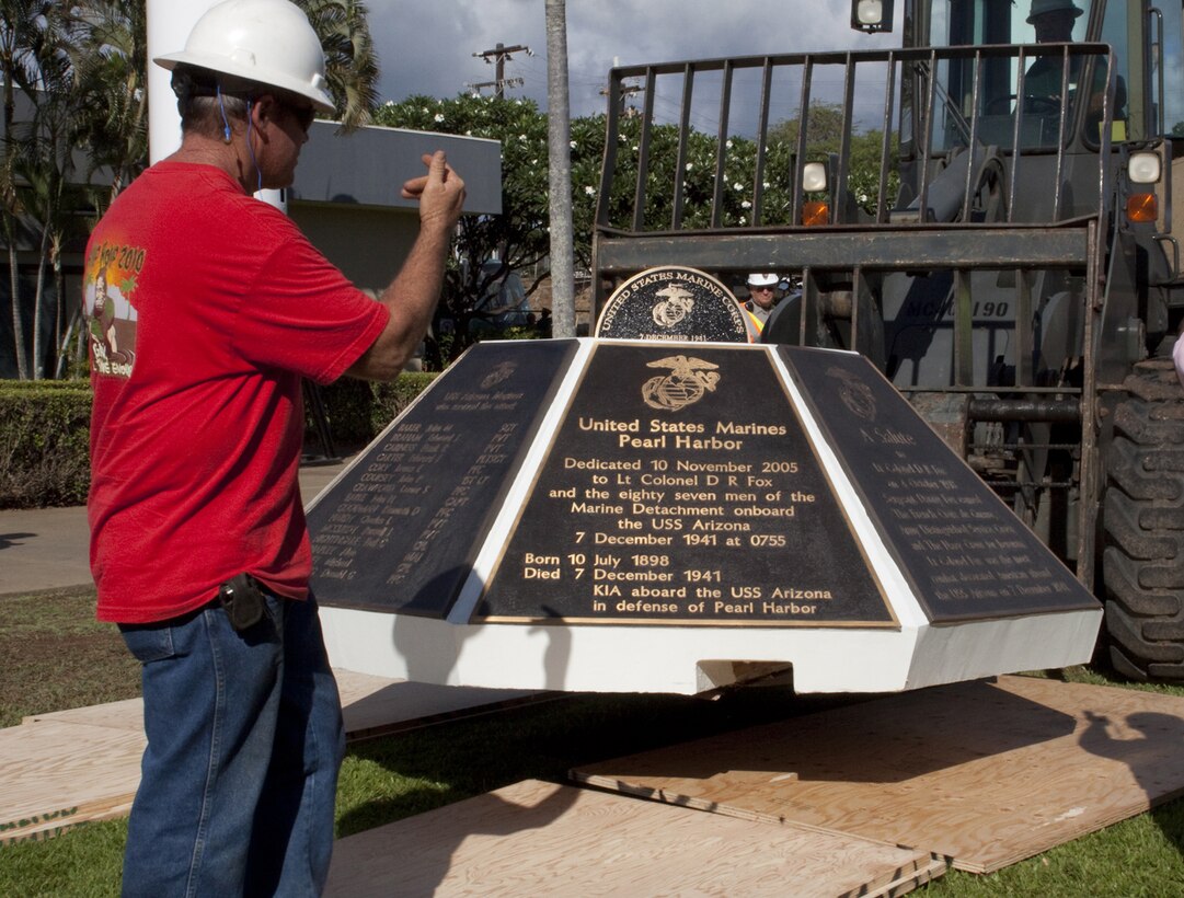 A construction worker with Naval Facilites Engineering Command Hawaii, guides the installation of the Marine memorial to be set in place at the USS Arizona Memorial and Visitor Center Sept. 14. The concrete base contains seven bronze plaques honoring 73 Marines who lie entombed in the USS Arizona since the attack on Pearl Harbor Dec. 7, 1941. (Official U.S. Marine Corps photo by Cpl. Cristina N. Porras) (Released)