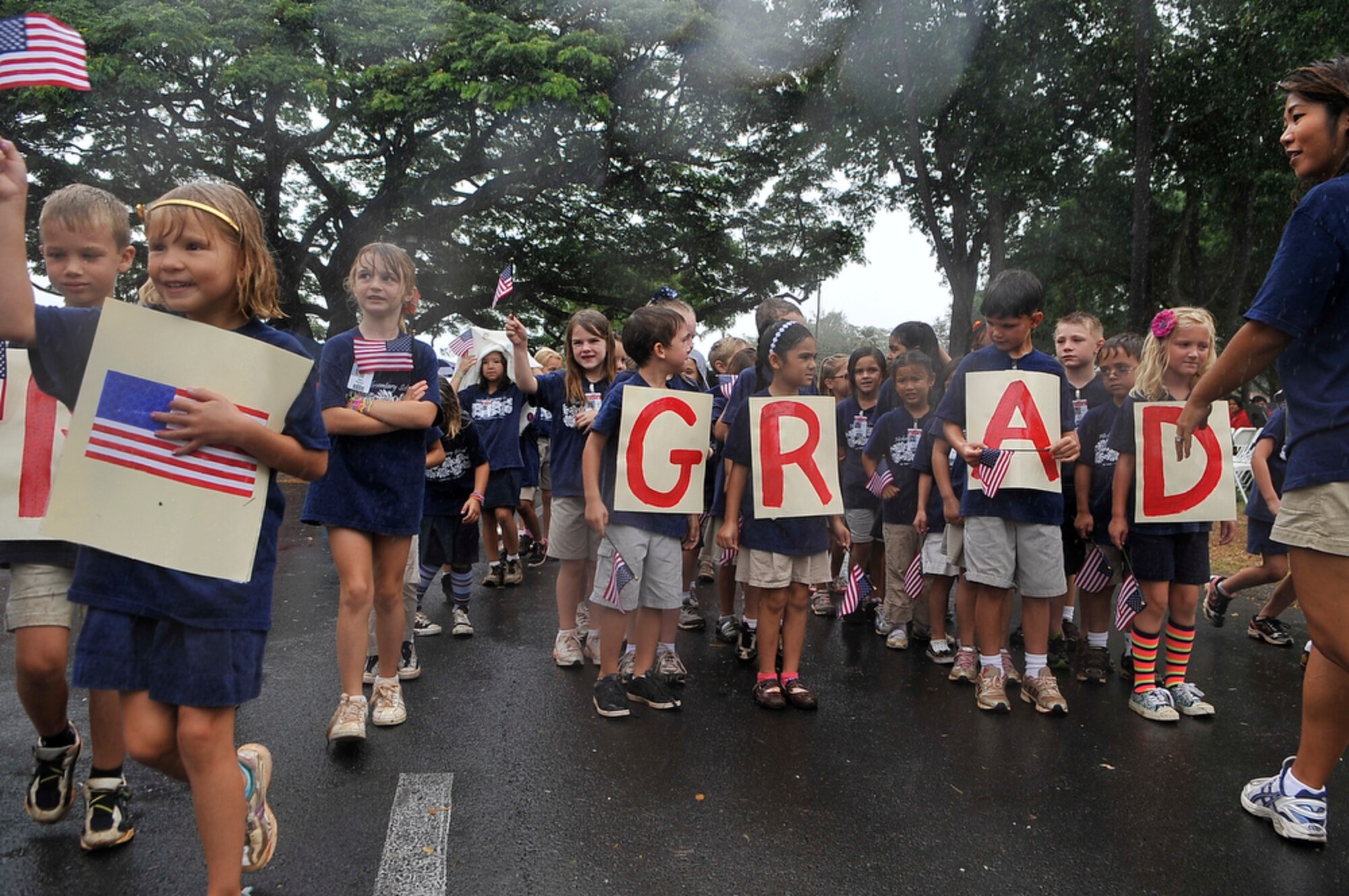 JOINT BASE PEARL HARBOR-HICKAM, Hawaii - First Graders from Hickam Elementary School, Joint Base Pear Harbor-Hickam, Hawaii wave their flags in the rain during their school's parade on Sept. 10 as part of their Second Annual 9/11 Observance Ceremony. More than 750 students from Hickam Elementary participated in the ceremony with the help of their teachers, parents and the Radford High School Color Guard and Band. (U.S.  Air Force photo/Tech Sgt. Cohen A. Young)