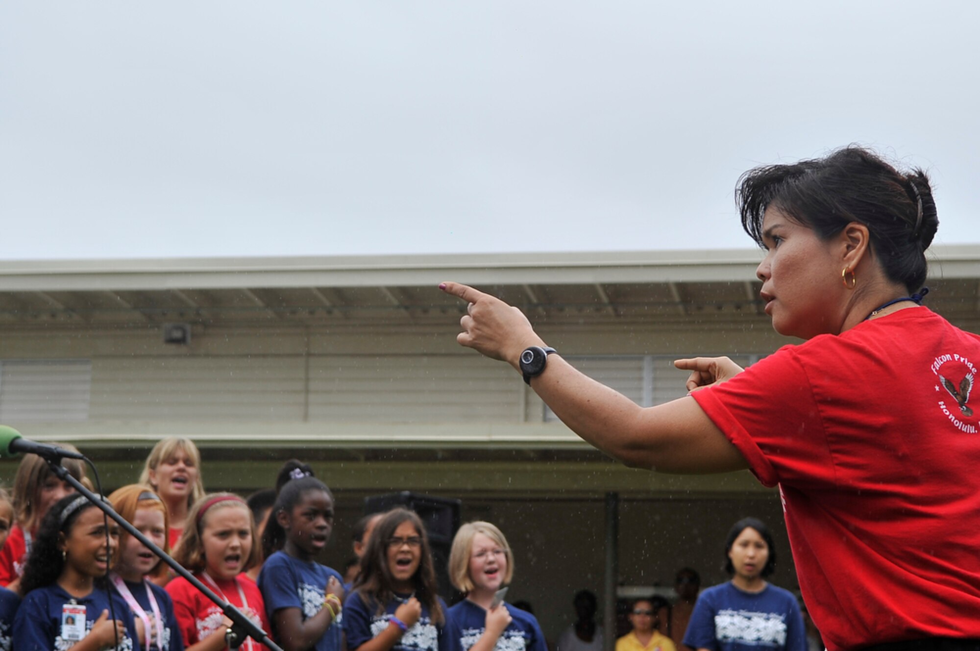 JOINT BASE PEARL HARBOR-HICKAM, Hawaii - Hickam Elementary School Music Director, Mrs. Tracie Higashi directs the choir while they sing the Hawaiian Anthem during the school's Second Annual 9/11 Observance Ceremony held on Sept. 10 at Joint Base Pear Harbor-Hickam, Hawaii. More than 750 students from Hickam Elementary participated in the ceremony with the help of their teachers, parents and the Radford High School Color Guard and Band. (U.S.  Air Force photo/Tech Sgt. Cohen A. Young)
