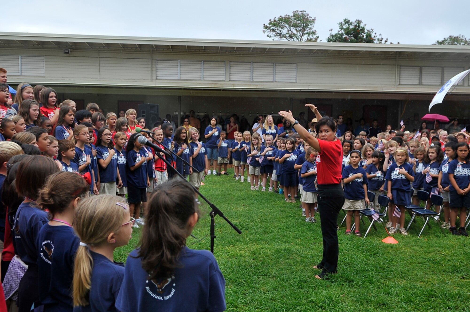 JOINT BASE PEARL HARBOR-HICKAM, Hawaii - Hickam Elementary School Music Director, Mrs. Tracie Higashi leads the choir in singing the National Anthem during the school's Second Annual 9/11 Observance Ceremony held on Sept. 10 at Joint Base Pear Harbor-Hickam, Hawaii. More than 750 students from Hickam Elementary participated in the ceremony with the help of their teachers, parents and the Radford High School Color Guard and Band. (U.S.  Air Force photo/Tech Sgt. Cohen A. Young)