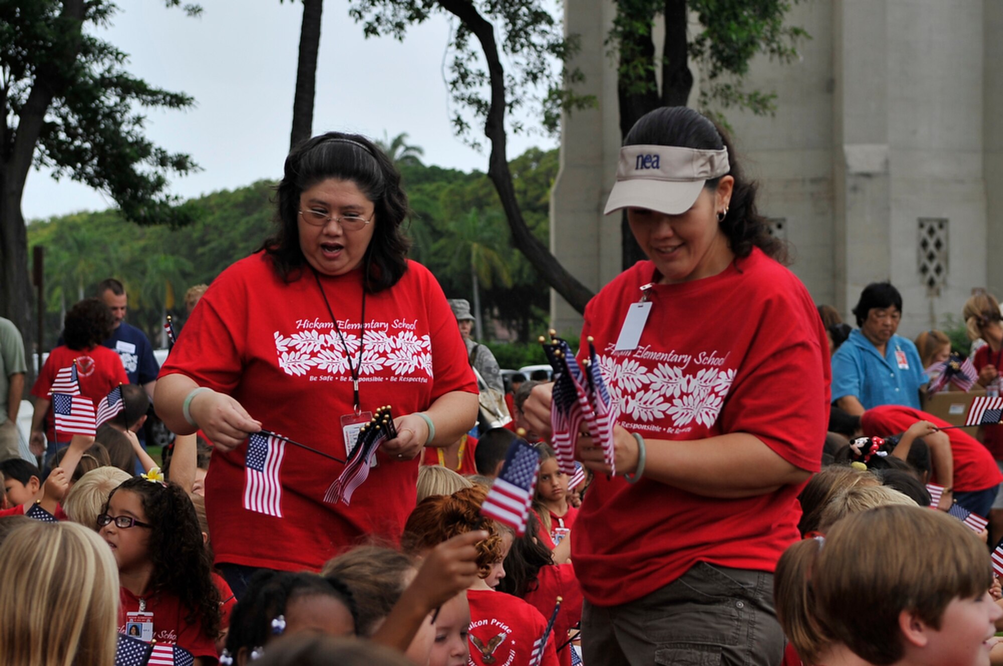 JOINT BASE PEARL HARBOR-HICKAM, Hawaii - Hickam Elementary School teachers, Mrs. JeAnn Williams (left) and Michele Sasaki distribute flags to their kindergarten classes during the school's Second Annual 9/11 Observance Ceremony held on Sept. 10 at Joint Base Pear Harbor-Hickam, Hawaii. More than 750 students from Hickam Elementary participated in the ceremony with the help of their teachers, parents and the Radford High School Color Guard and Band. (U.S.  Air Force photo/Tech Sgt. Cohen A. Young)